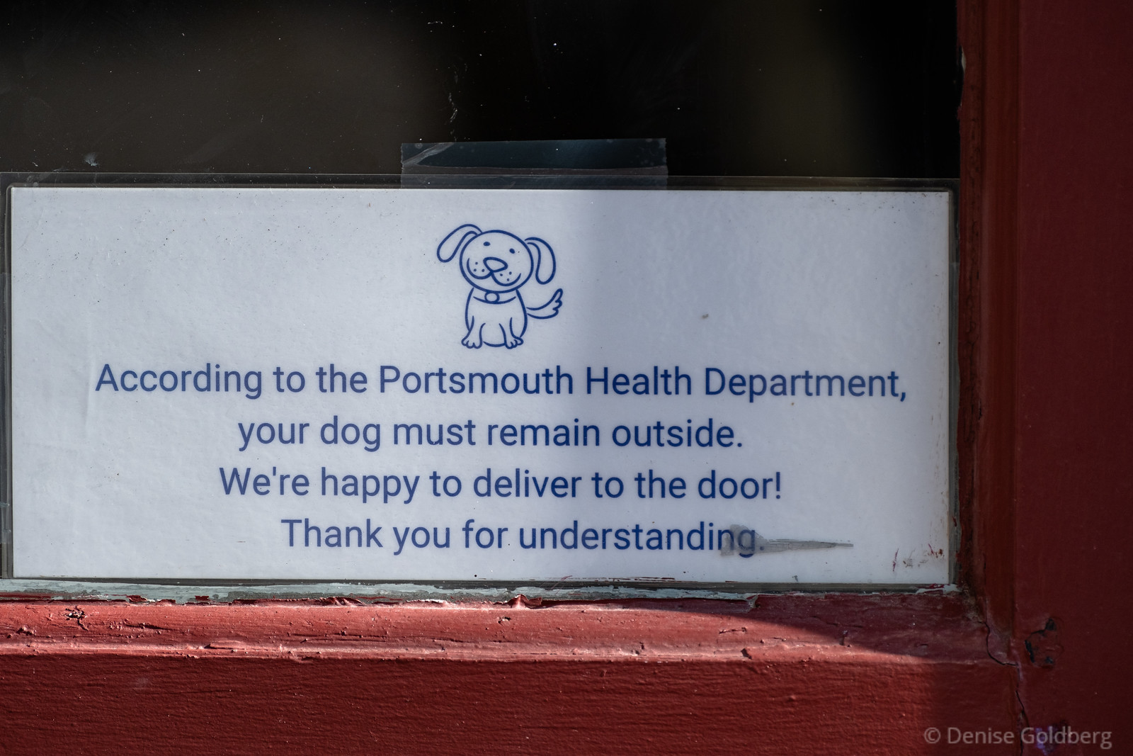 sign in the window of an ice cream shop in Portsmouth, NH.

Your dog must remain outside. We're happy to deliver to the door!