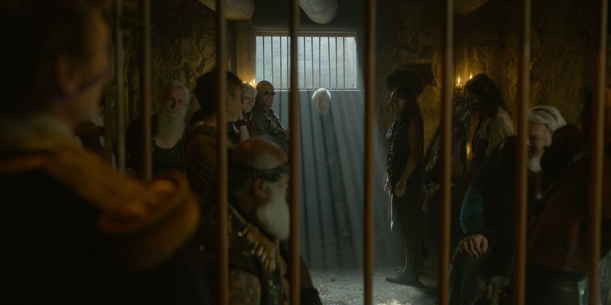 Izzy standing with other imprisoned pirates in the season two finale.