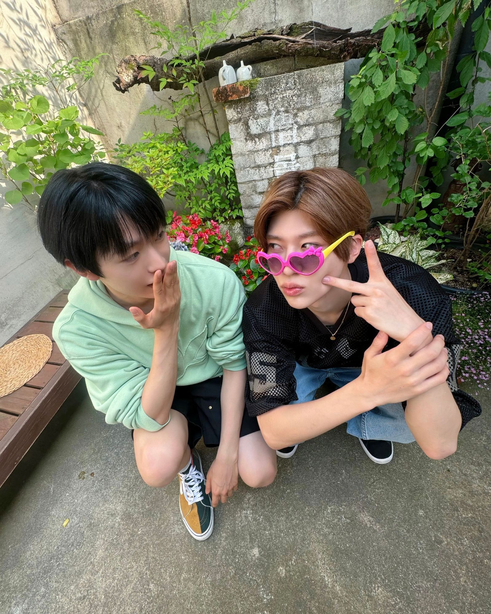 the second of the two set and yushi has his hand up in surprise as he's looking at sion holding up a peace sign and pouting his lips in a kiss