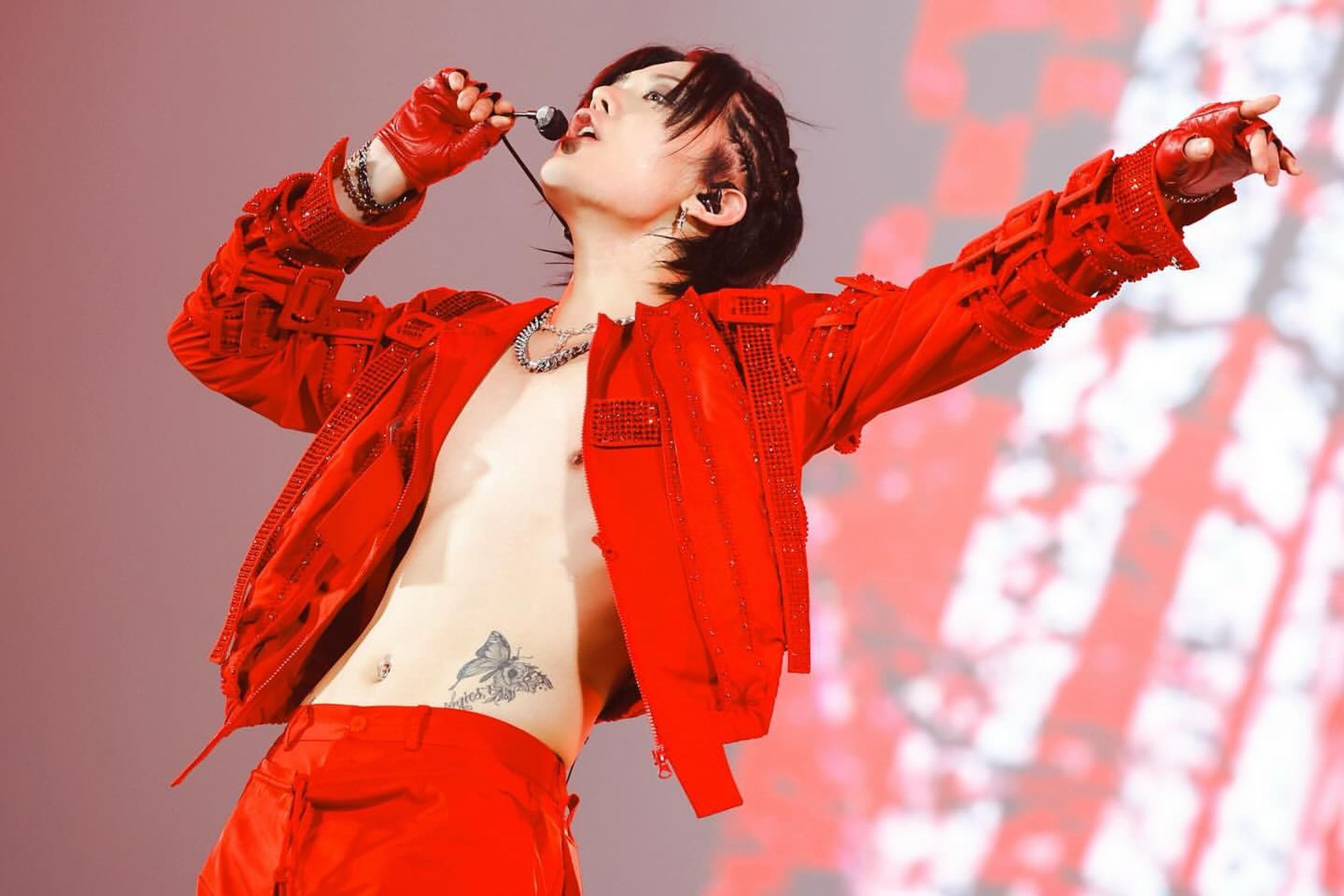 sexy hot shirtless yuta in his red concert outfit, hands pointing out to the crowd, his butterfly tattoo in full view