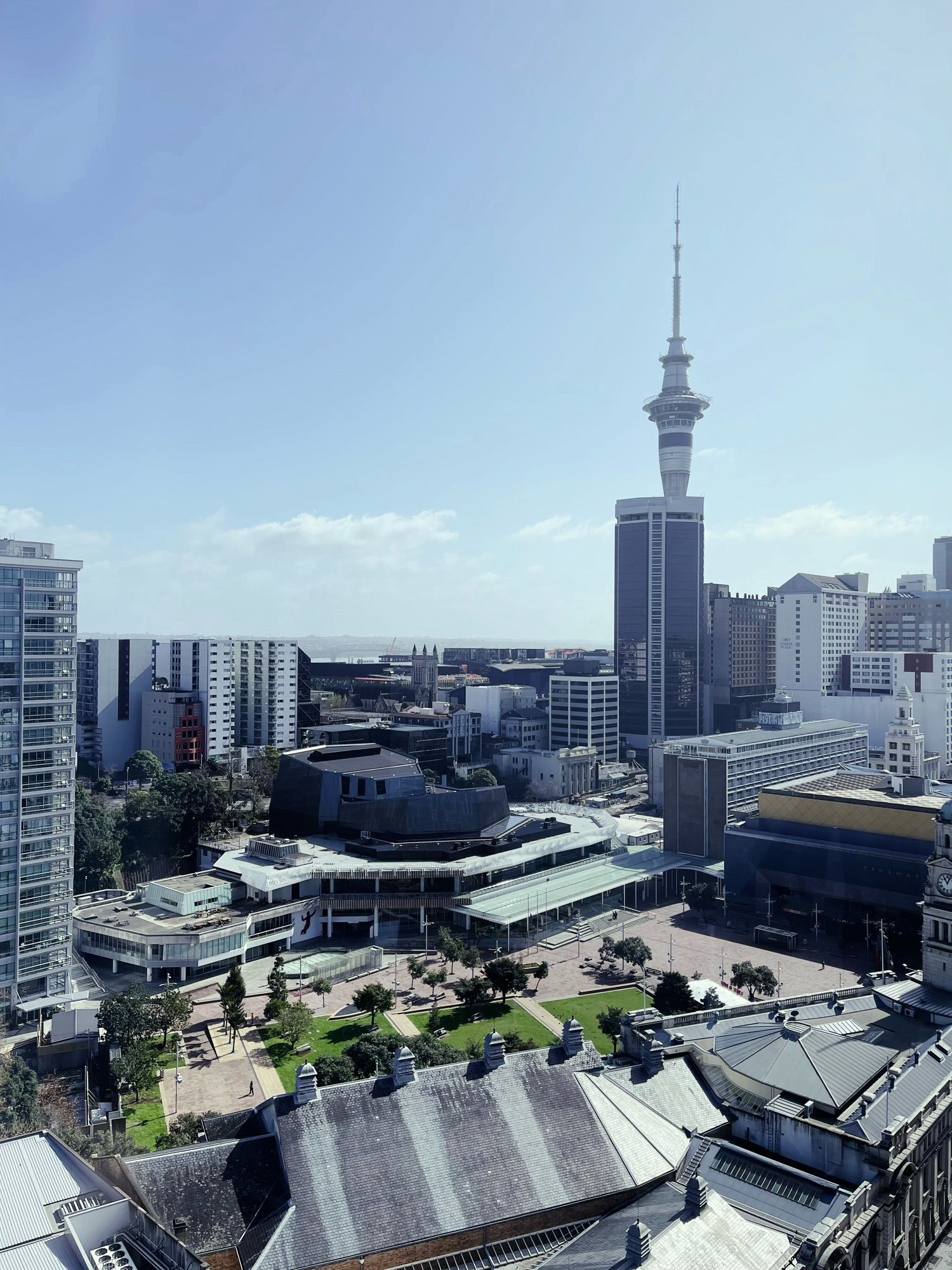 picture of the Sky Tower with Aotea Square in the foreground and the Auckland Harbour Bridge in the background