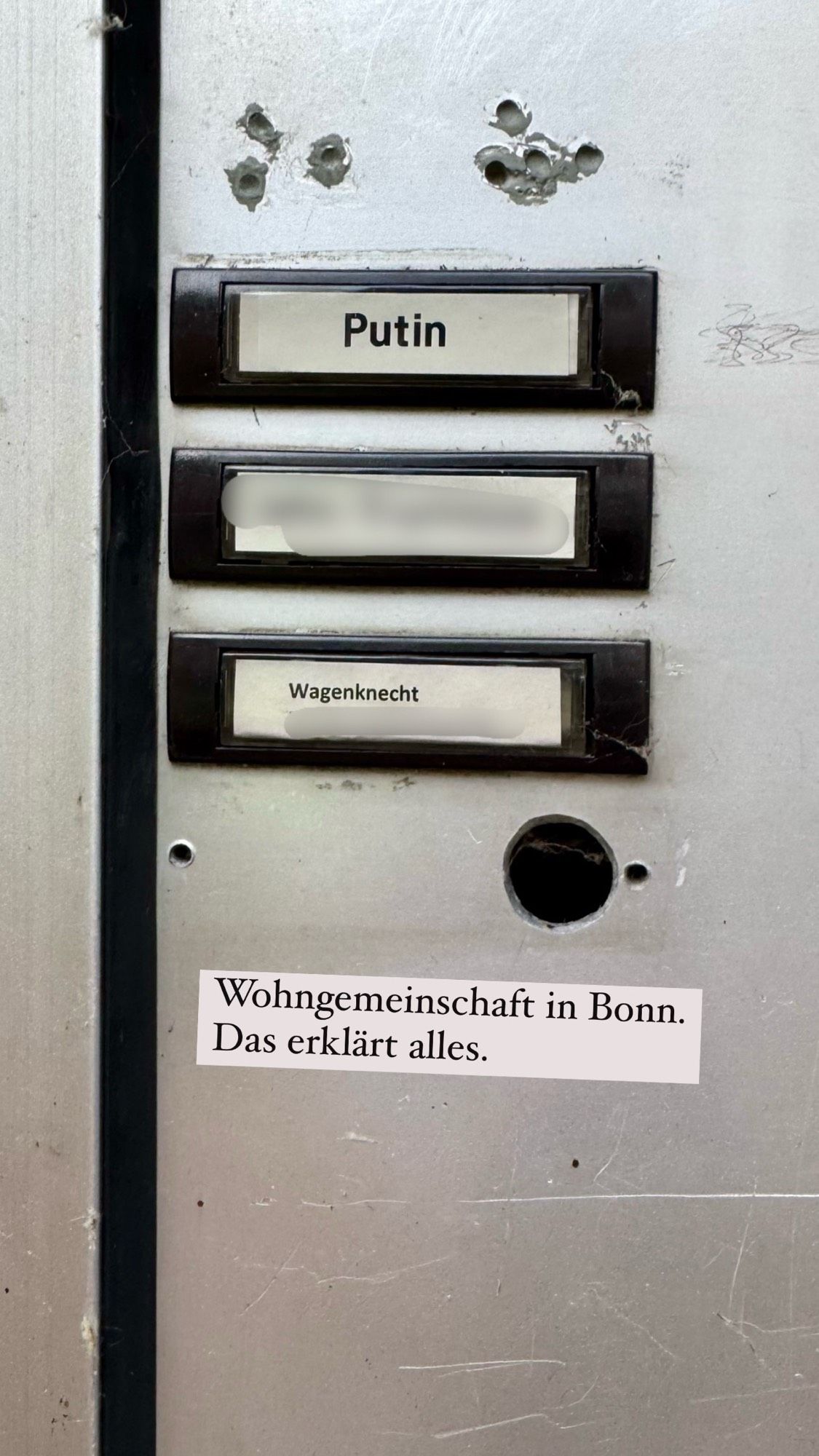 Klingelschilder eines Hauses. Oben wohnt Putin, unten Wagenknecht.