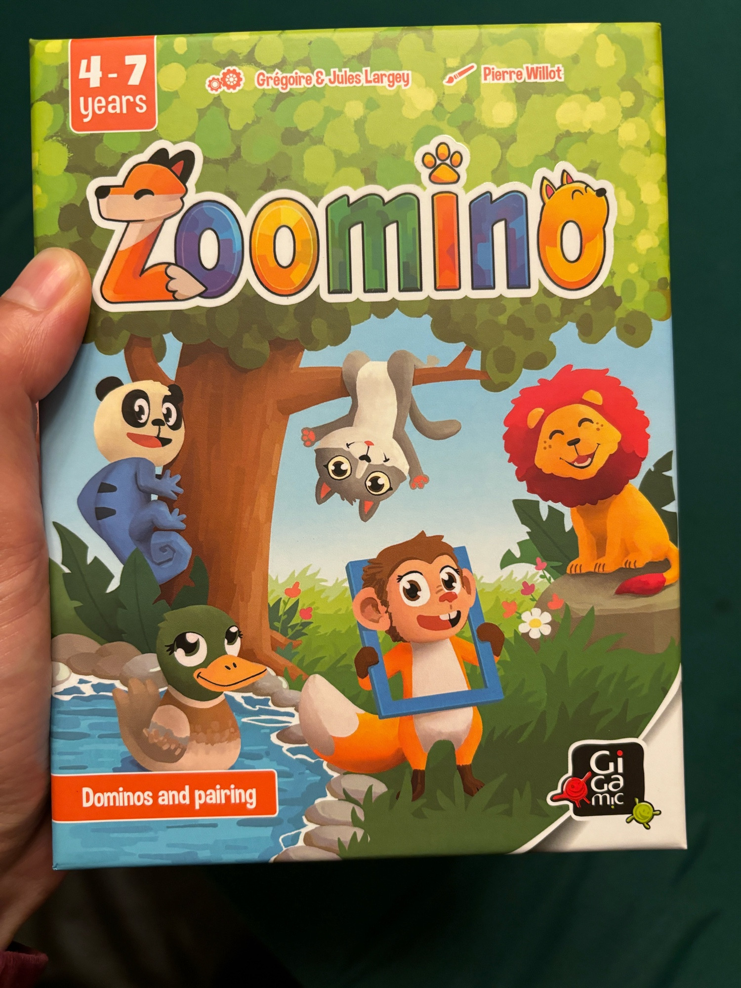 Zoomino board game box. Some actual animals, and also a monkey head with a fox body holding a picture frame.