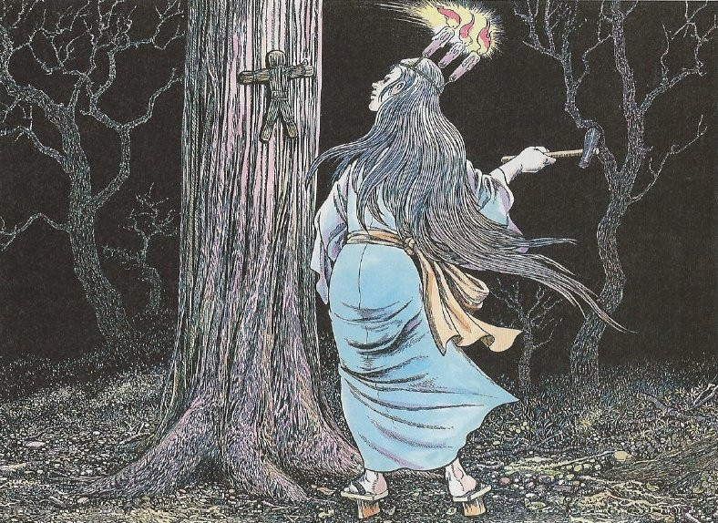 At night a woman stands beside a tree to which a small straw human-shaped object is attached. She holds a hammer and on her head are three burning candles.