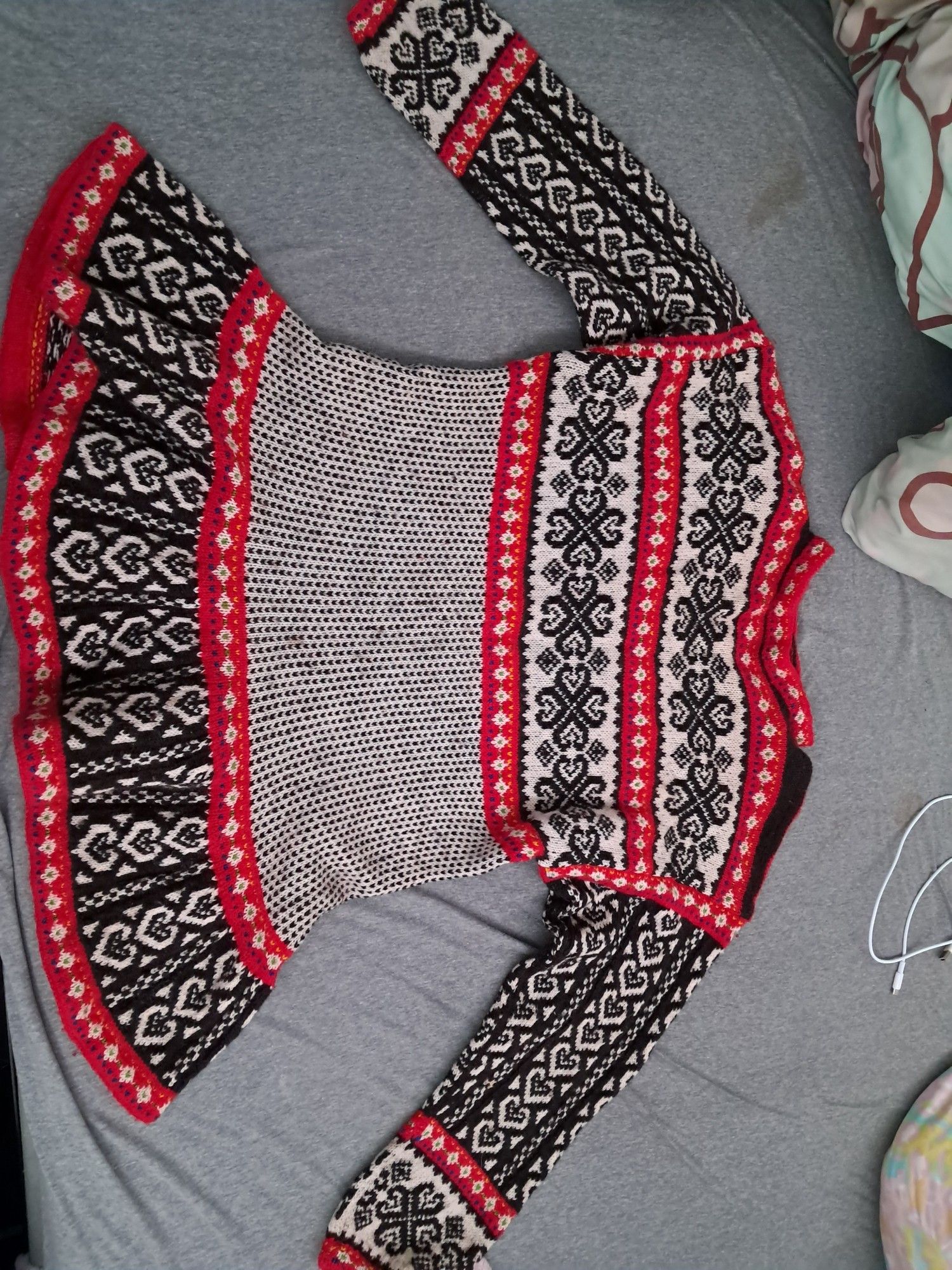 An old, handknitted sweater/cardigan/tunic sort of thing, with the colours in red, white and black. It has heart shapes in it aswell