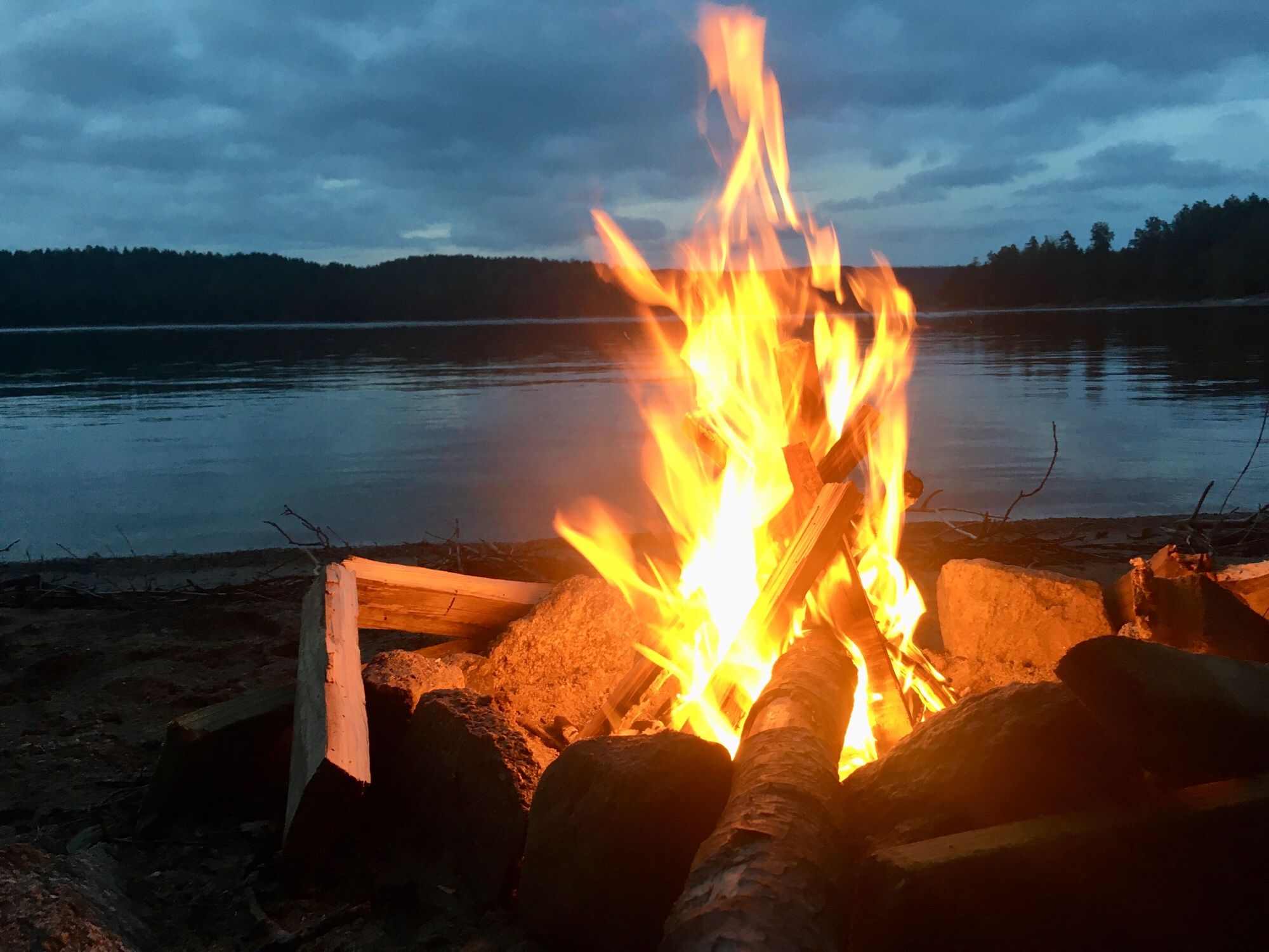 Lagerfeuer direkt am Ufer eines Sees in Schweden.