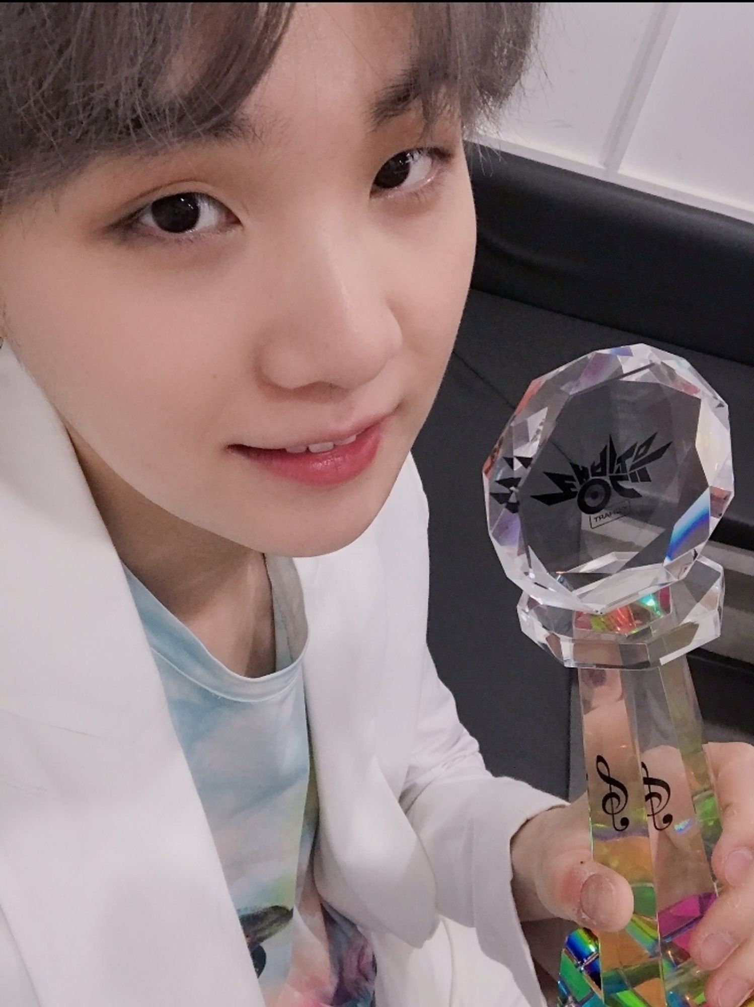 SUGA of BTS holding a trophy