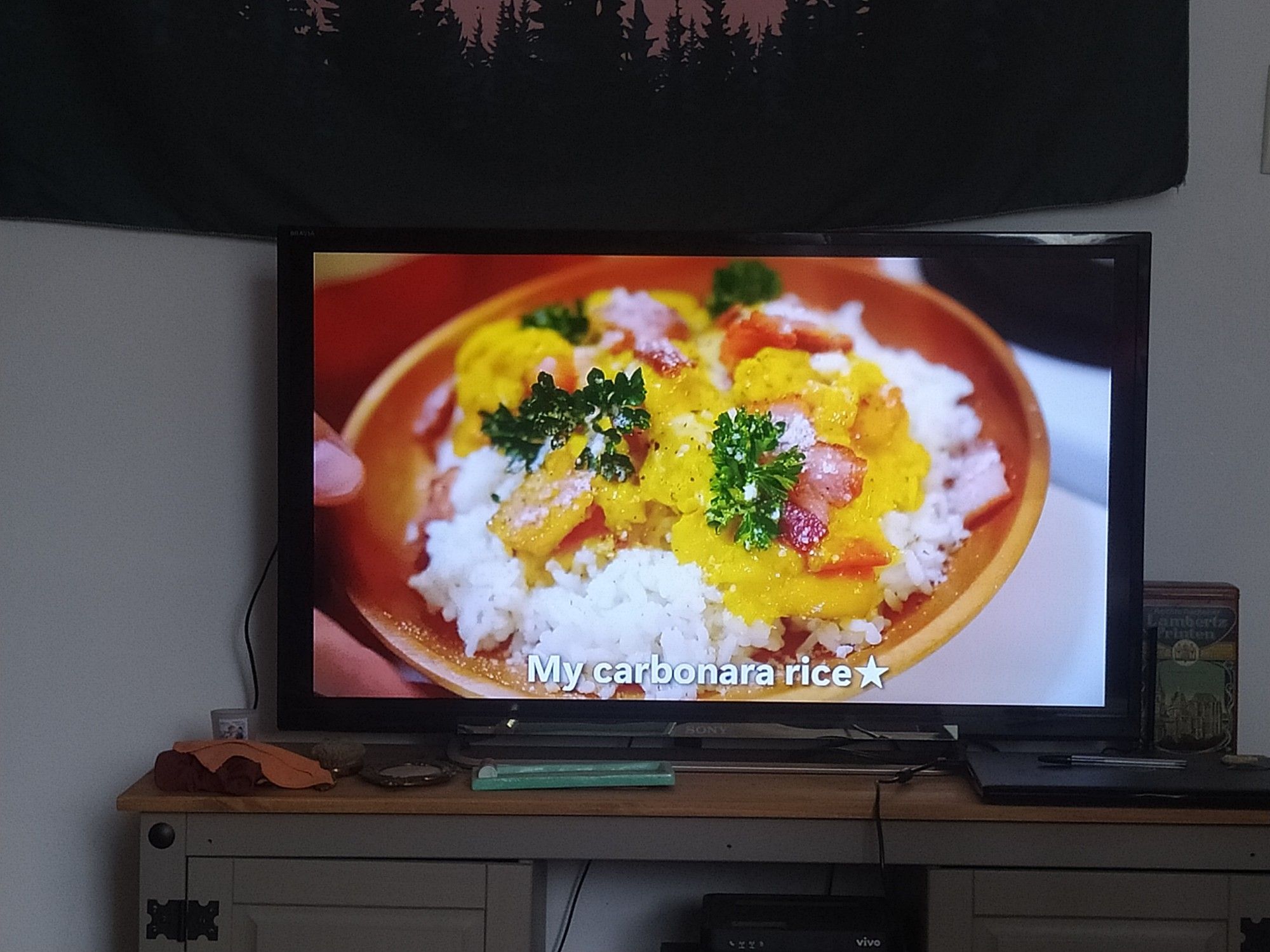 um prato bege com arroz, ovo mexido com bacon e ervas por cima 