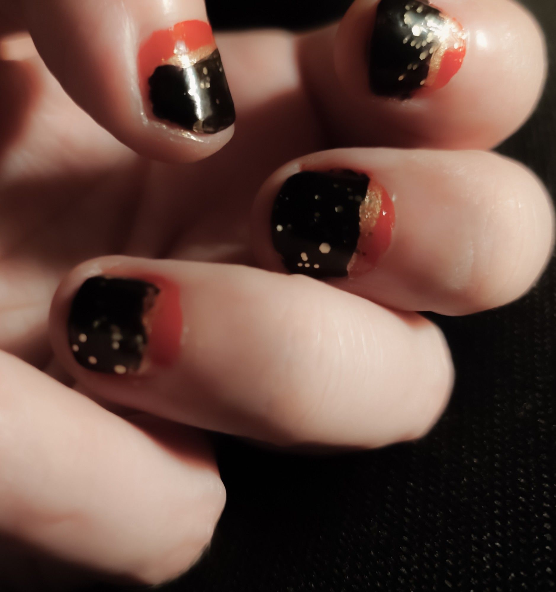 My black nails with a little gold and a little red and a little glitter