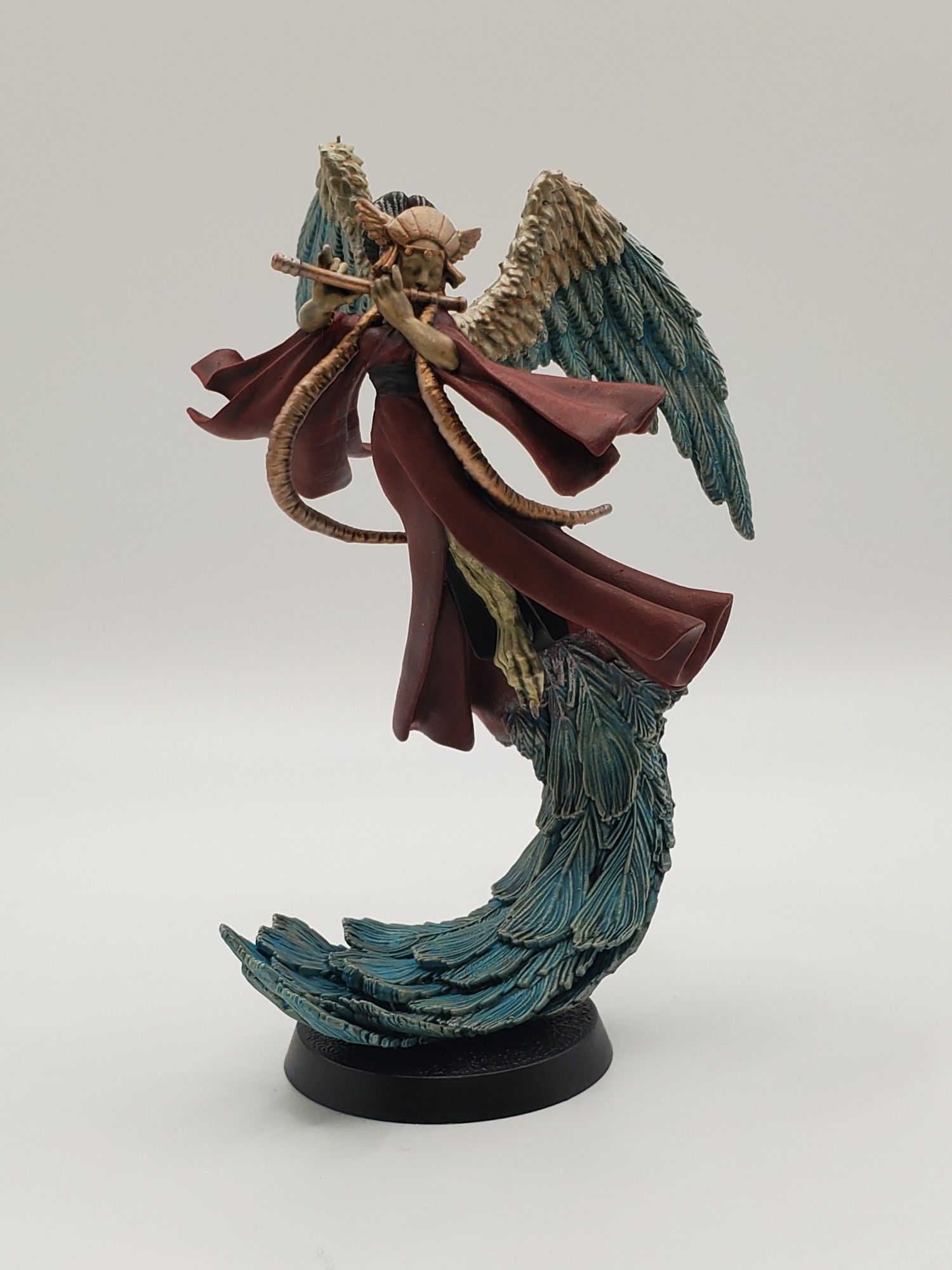 A mythical Japanese bird called Karyōbinga- she has blue feathered wings and tail, a red robe, pale skin, and gold details