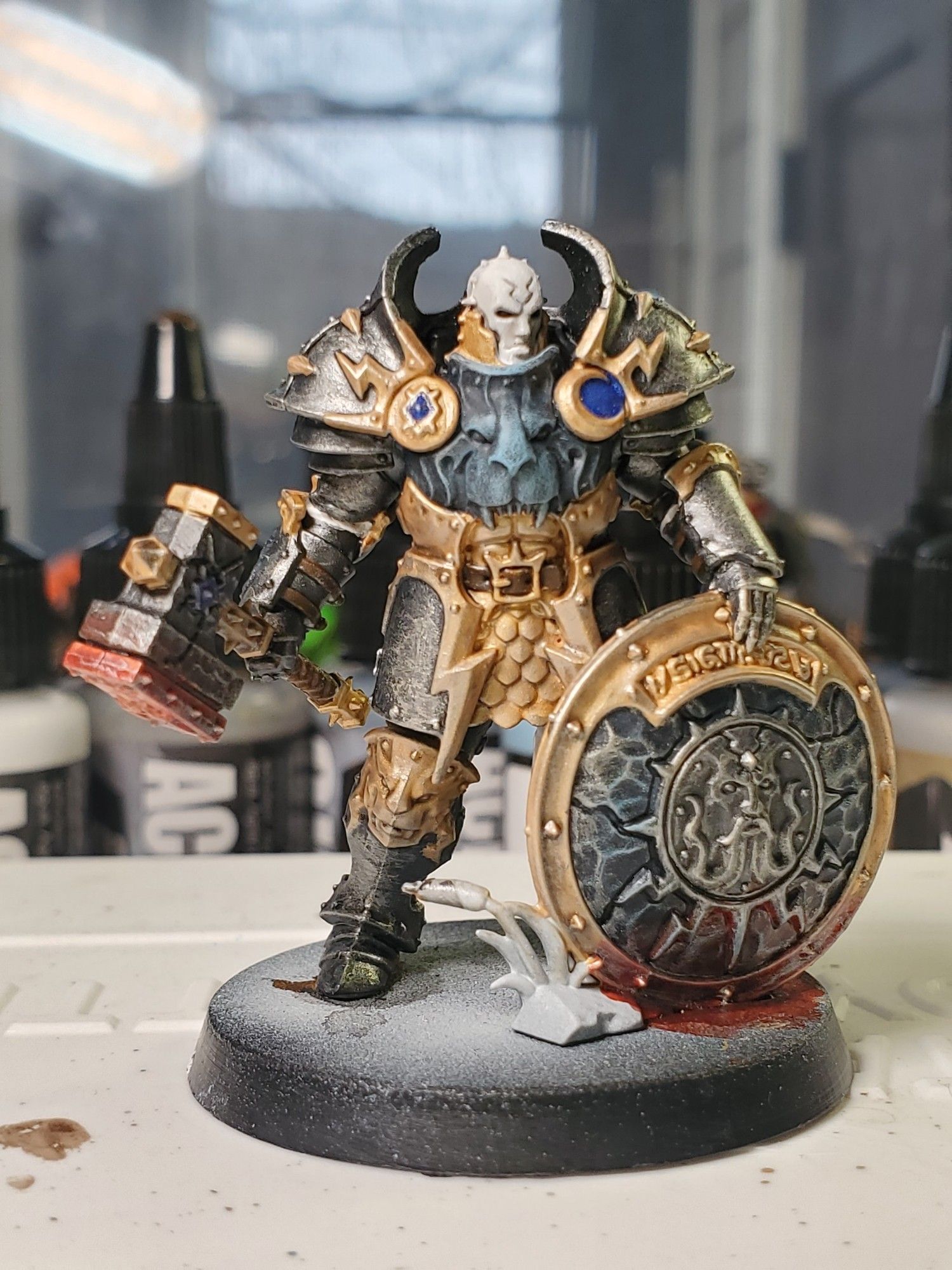 A Warhammer Age of Sigmar Stormcast Annihilator painted in dark silver, bright gold, and blue/grey