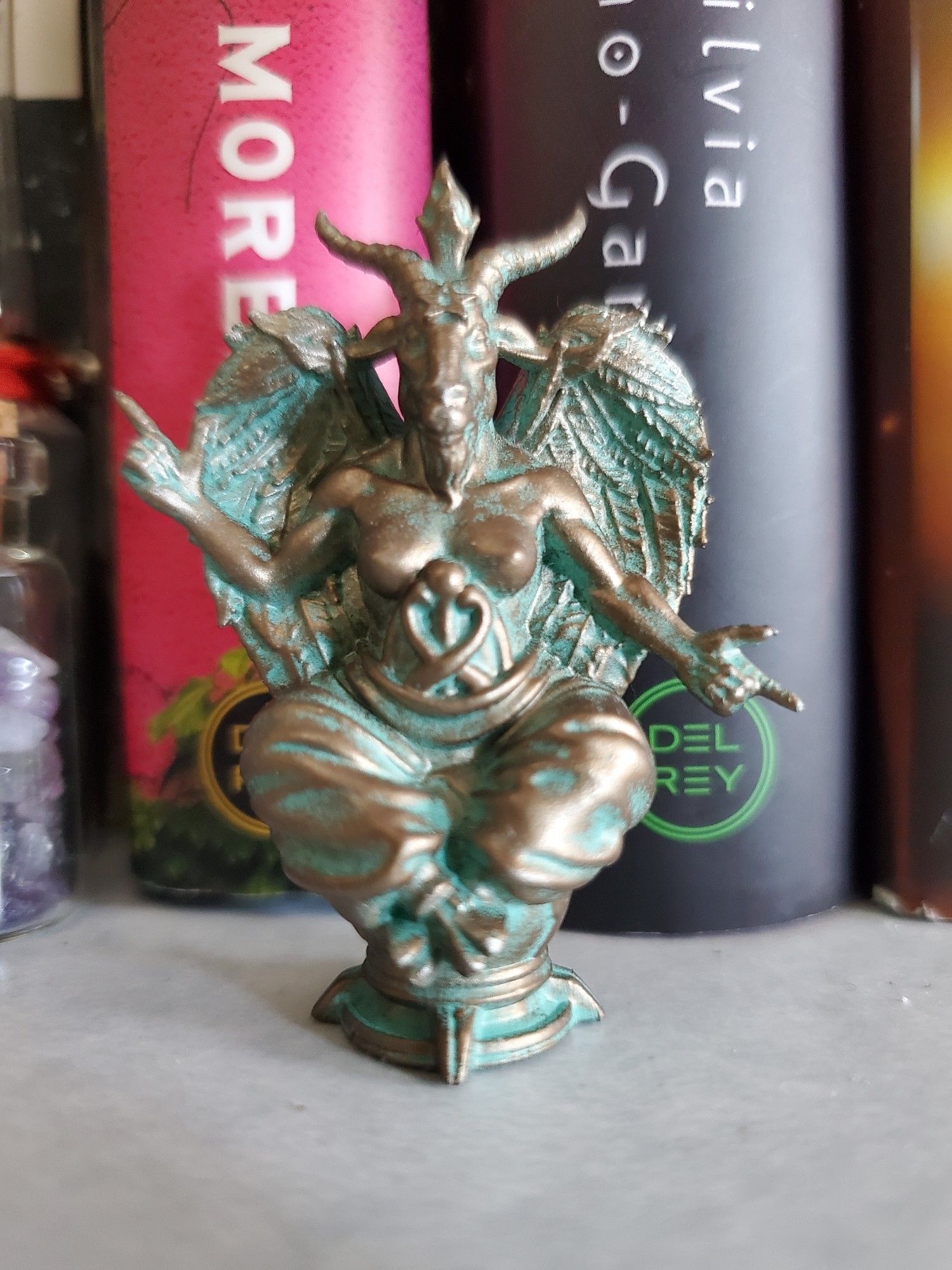 A baphomet statue painted to be copper and verdigris