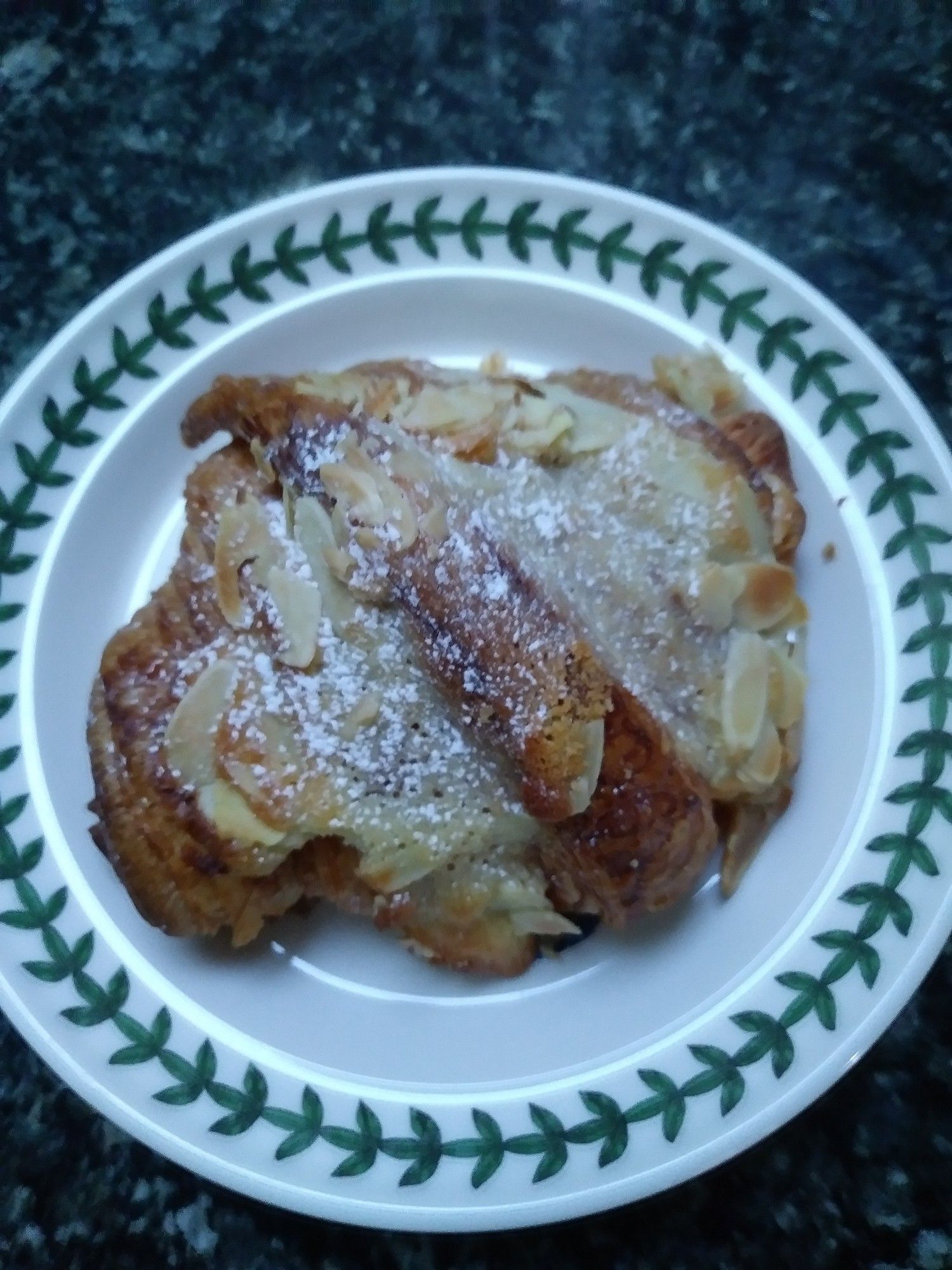 Buttery almond croissant on a small plate.