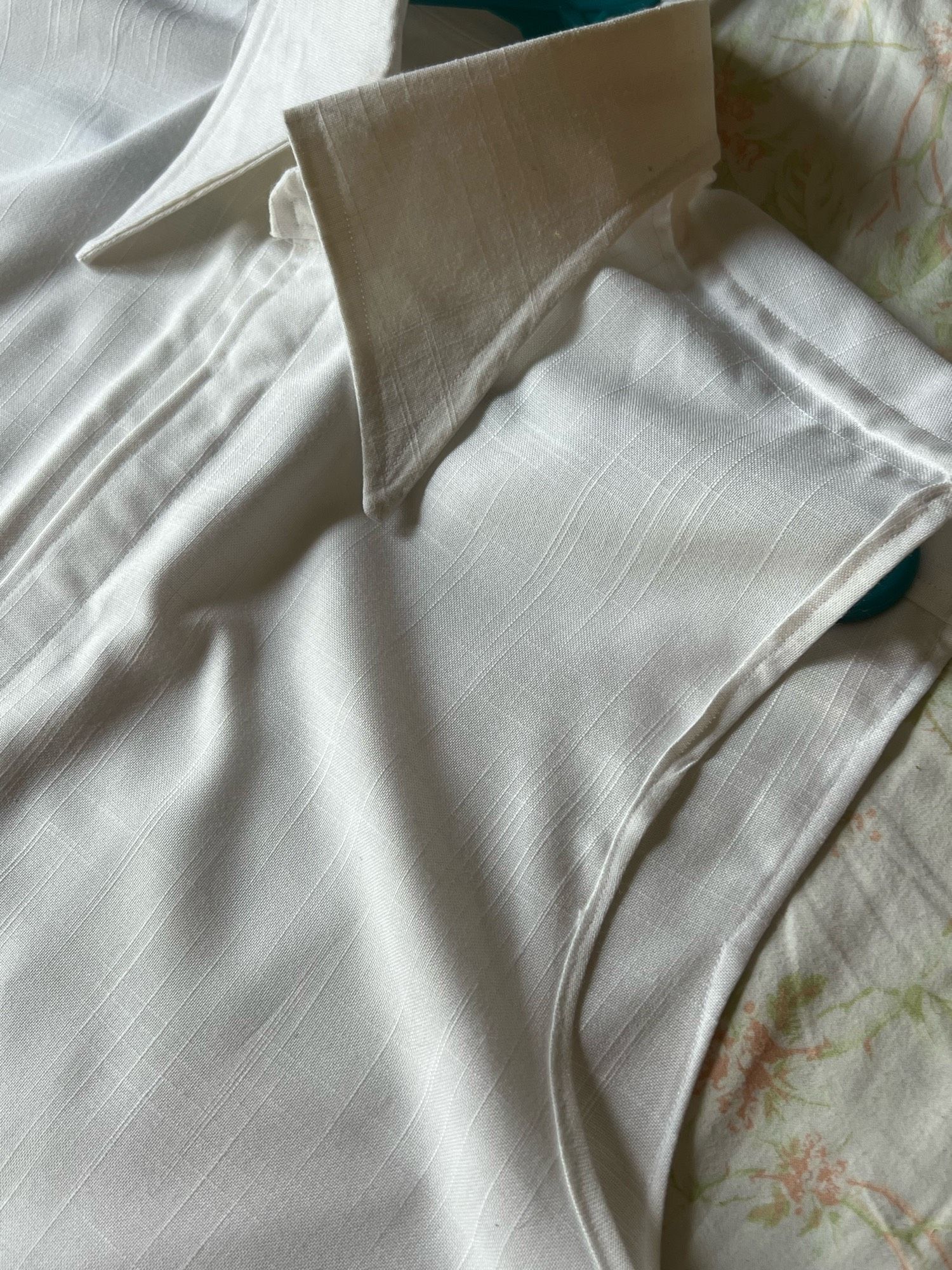 A white linen sleeveless shirt with a large exaggerated collar.