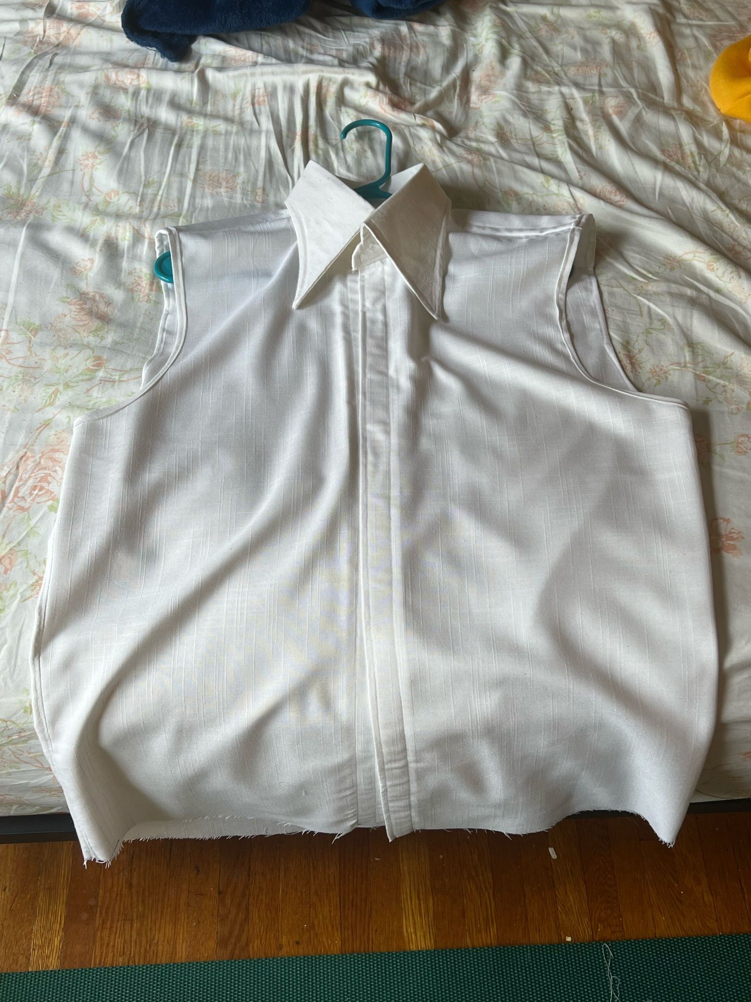 A full shot of a white linen sleeveless shirt with a large exaggerated collar