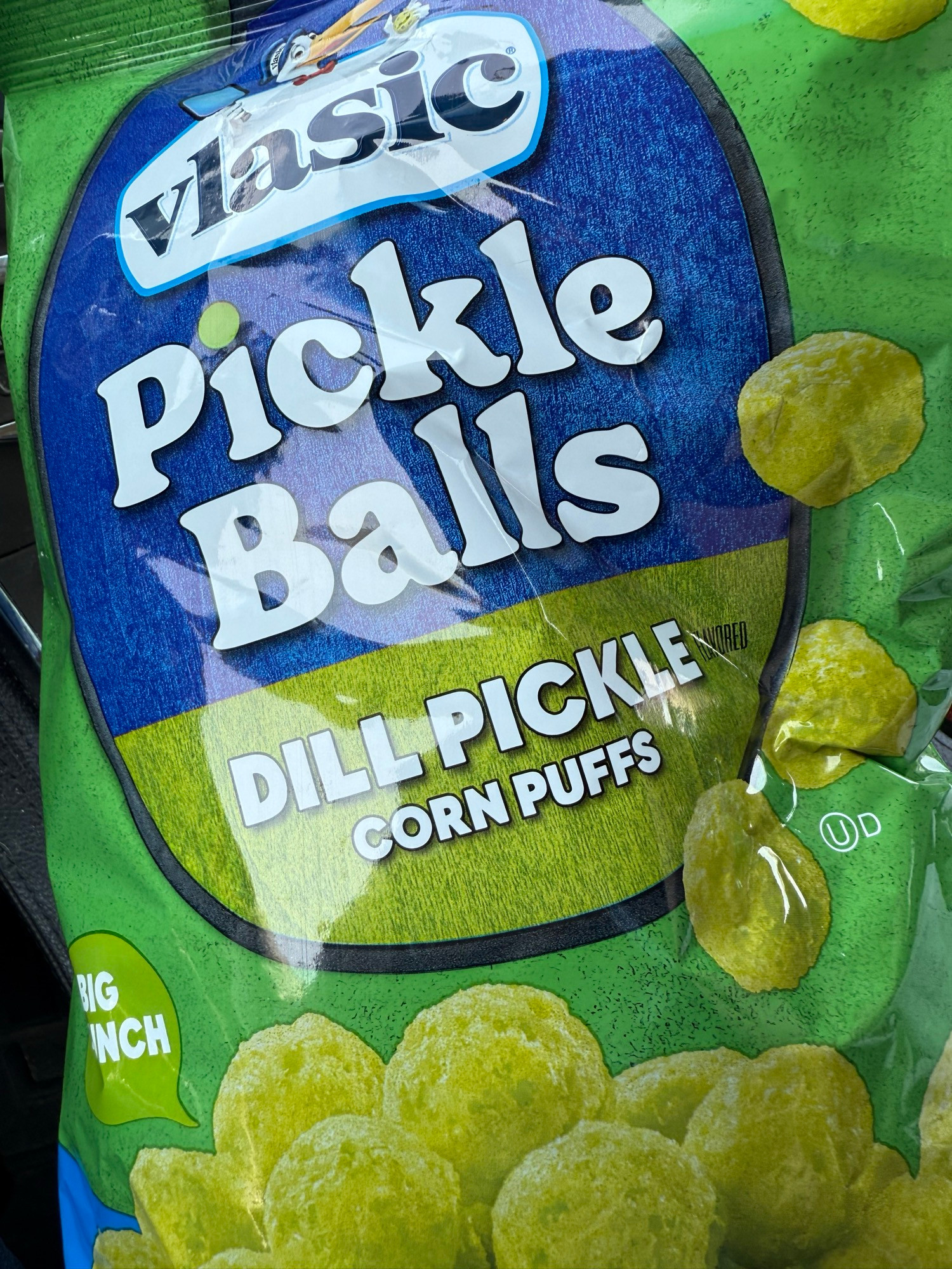 Green chip bag labeled “Vlasic Pickle Balls, dill pickle corn puffs,” with a photo of pale green corn puffs, similar to the usual orange-colored cheese puffs. 