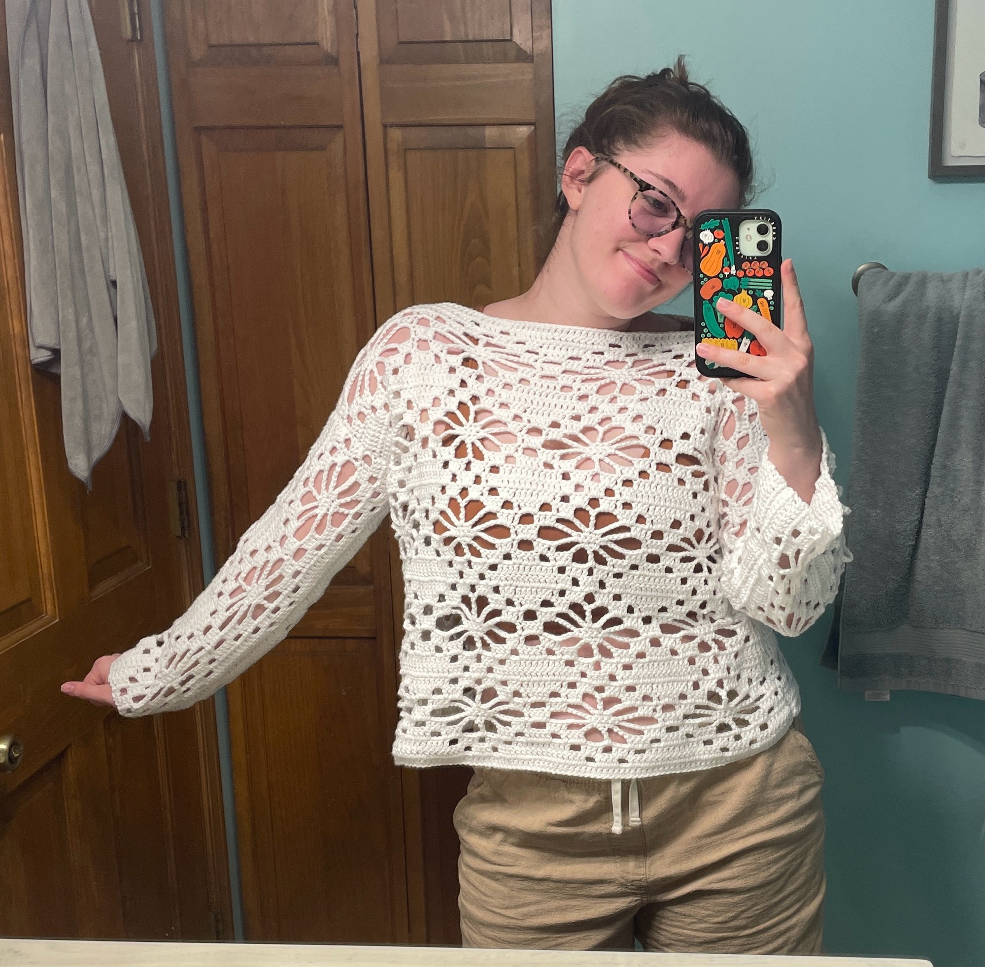 mel posing in a crocheted white flower top that they made 