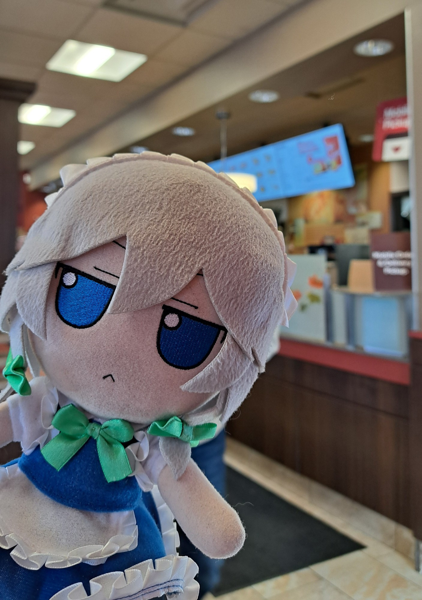 Sakuya staring into the camera, with the interior of Tim Hortons in the background.