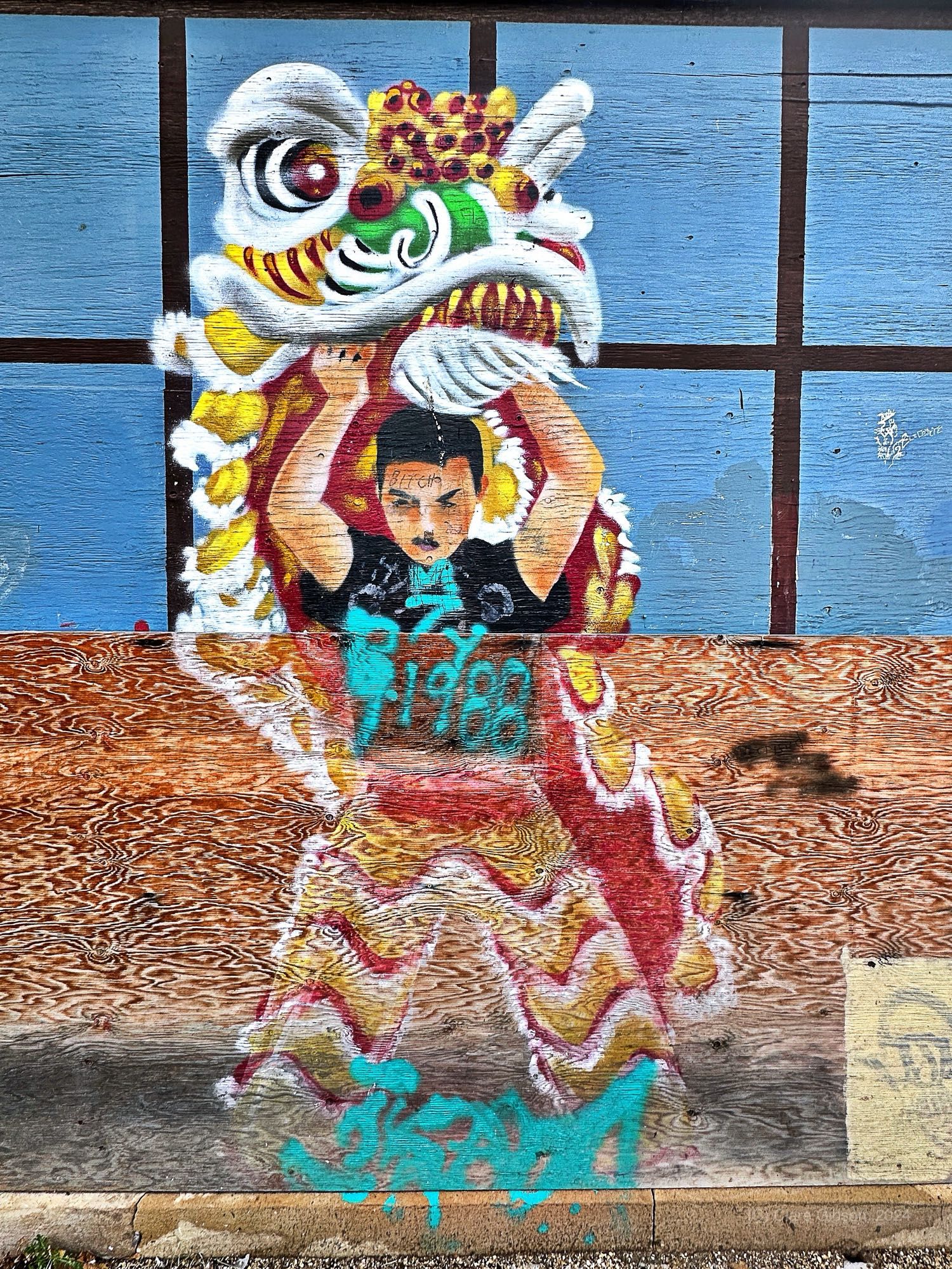 Mural of man holding up Chinese dragon