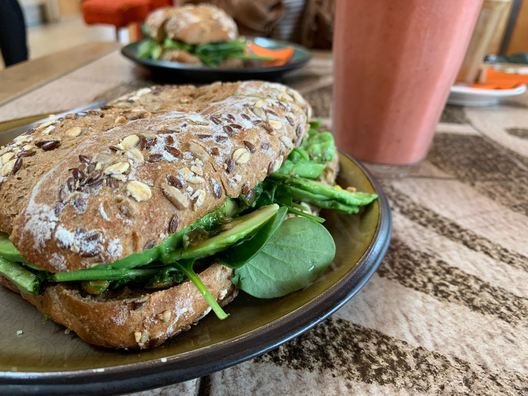 Ein Panini mit Avocado und ein roter Smoothie