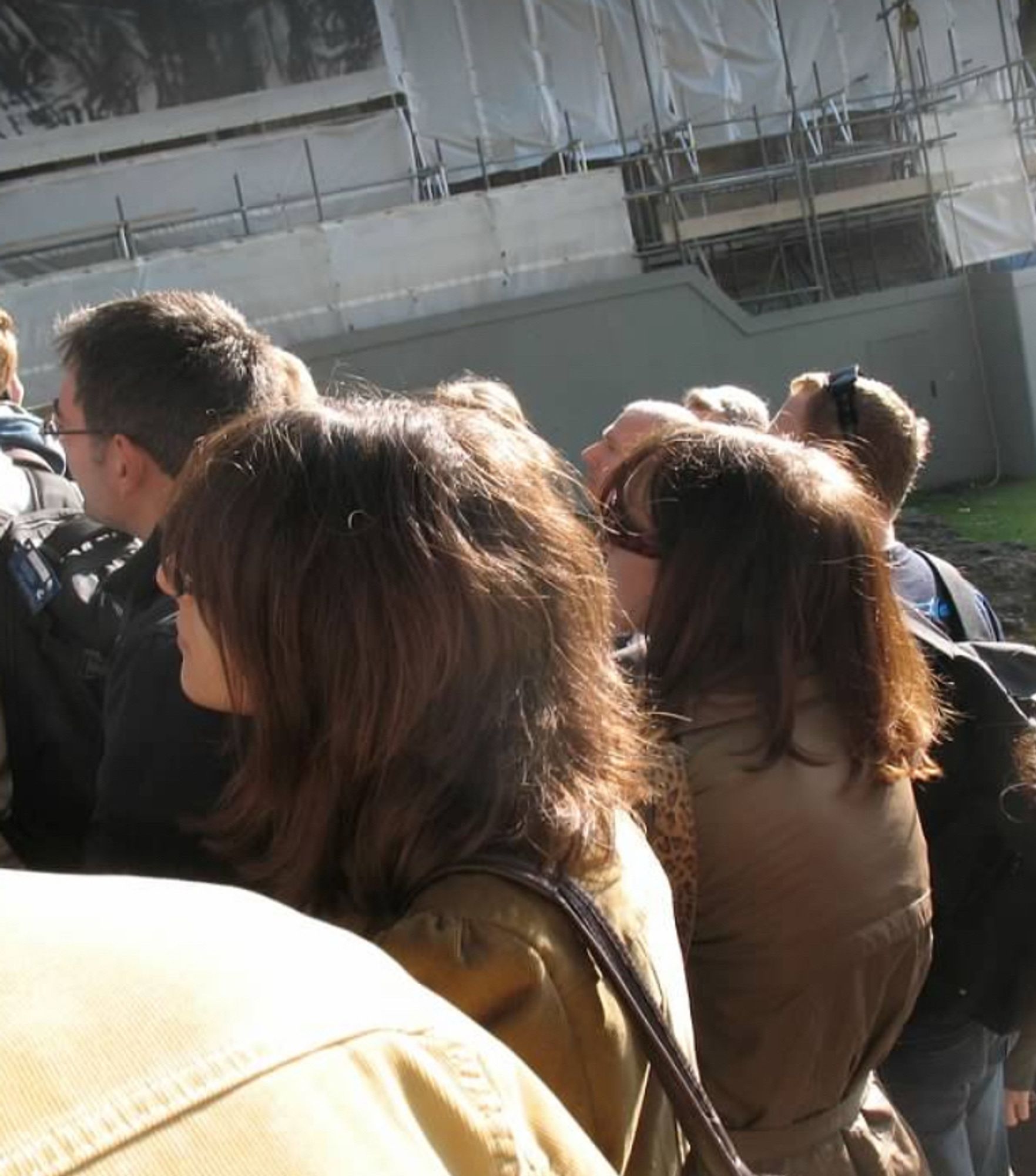 Two brunette women wearing olive jackets and sunglasses; their hairstyles are similar as is what you can see of each of their faces