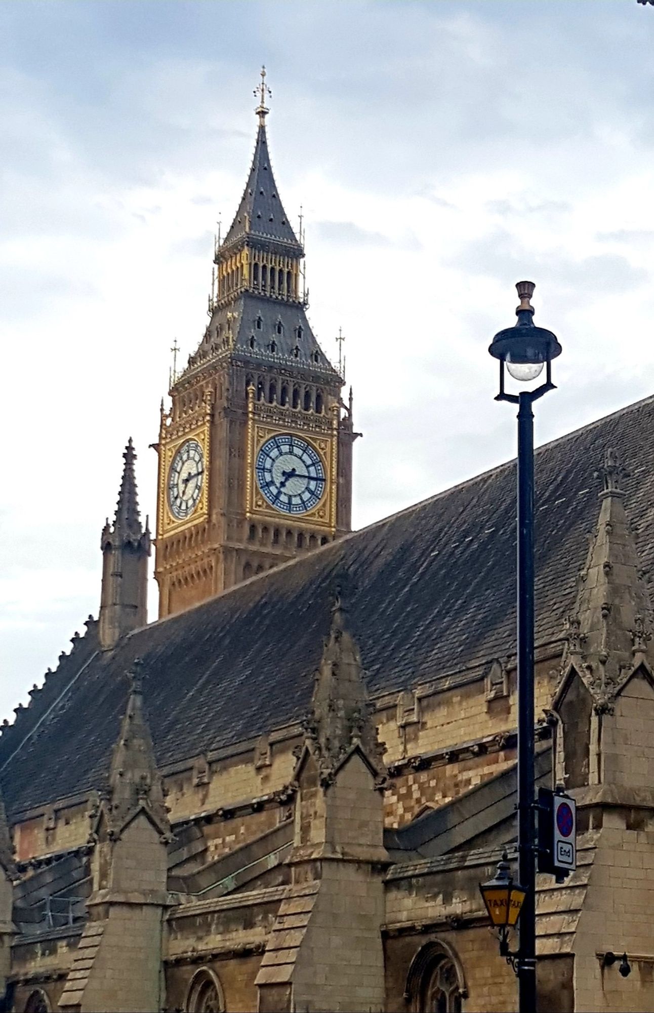 Big Ben peeking over the Houses of Parliament all golden in the evening light