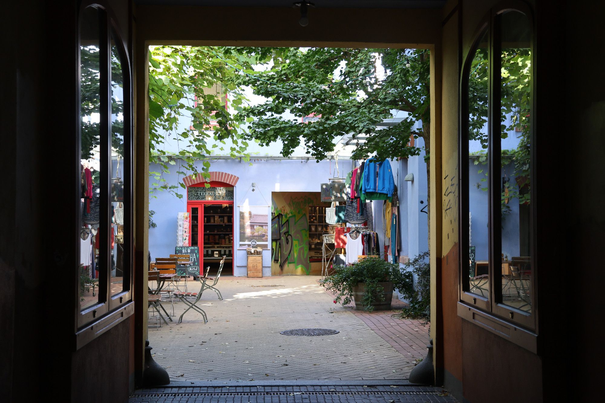 Blick durch eine Passage in einen sonnendurchfluteten Innenhof.