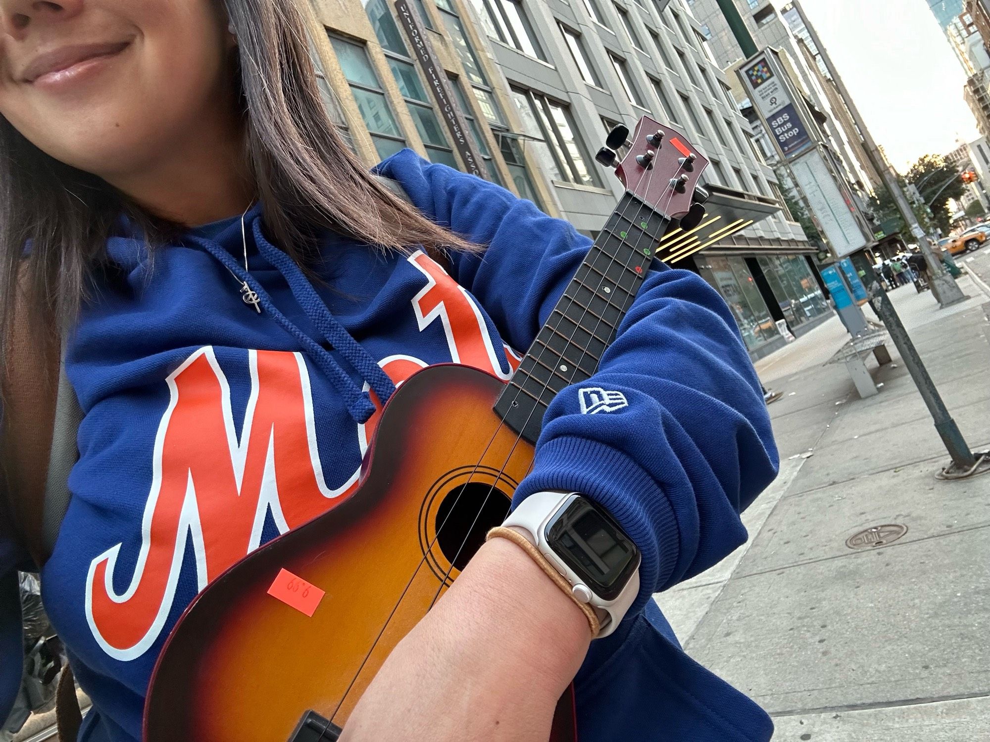 Woman holding a uke, waiting for the bus