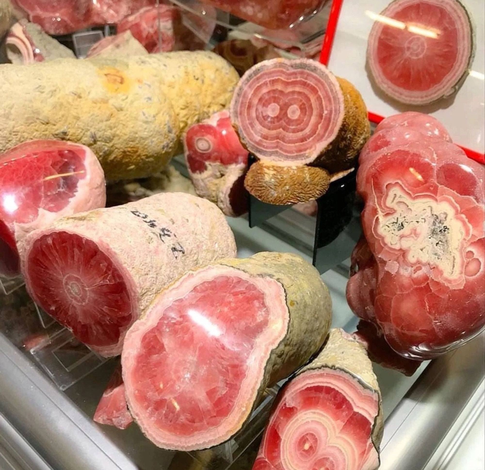 An image that looks like a deli counter filled with hams but it’s actually a pile of rhodochrosite.