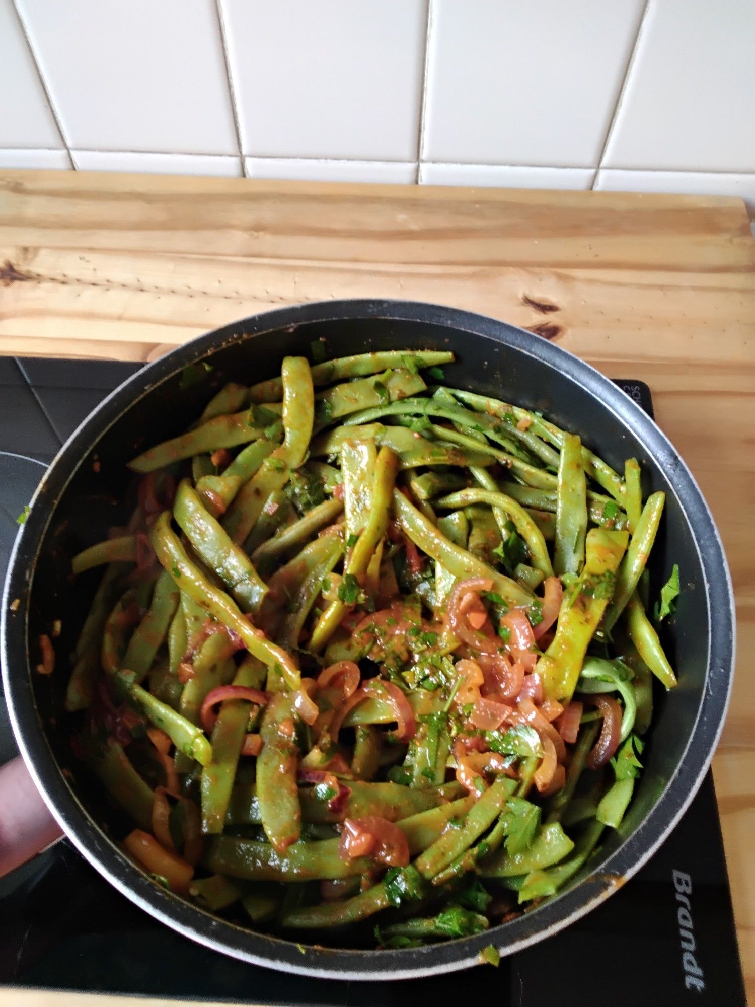 Haricots plats cuisinés à la sauce tomates et oignons rouges