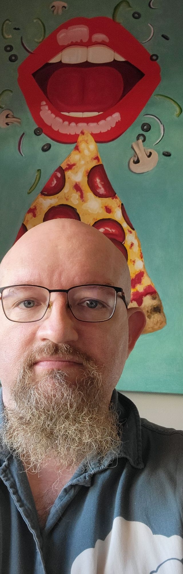 Your humble host in front of a picture of a slice of pizza under suggestive lips