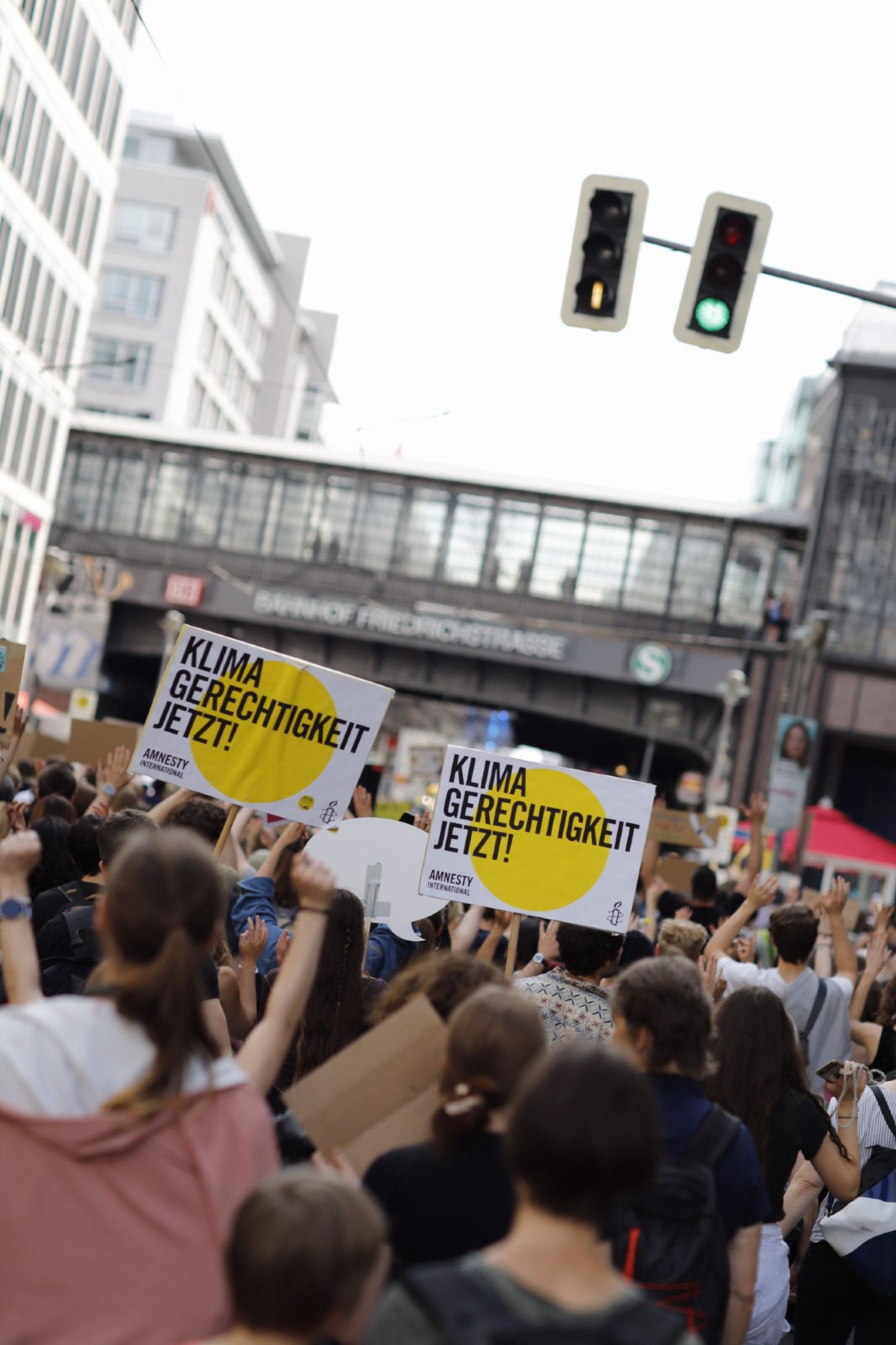 Demonstrant*innen halten Schilder mit "Klimagerechtigkeit jetzt" in die Höhe.