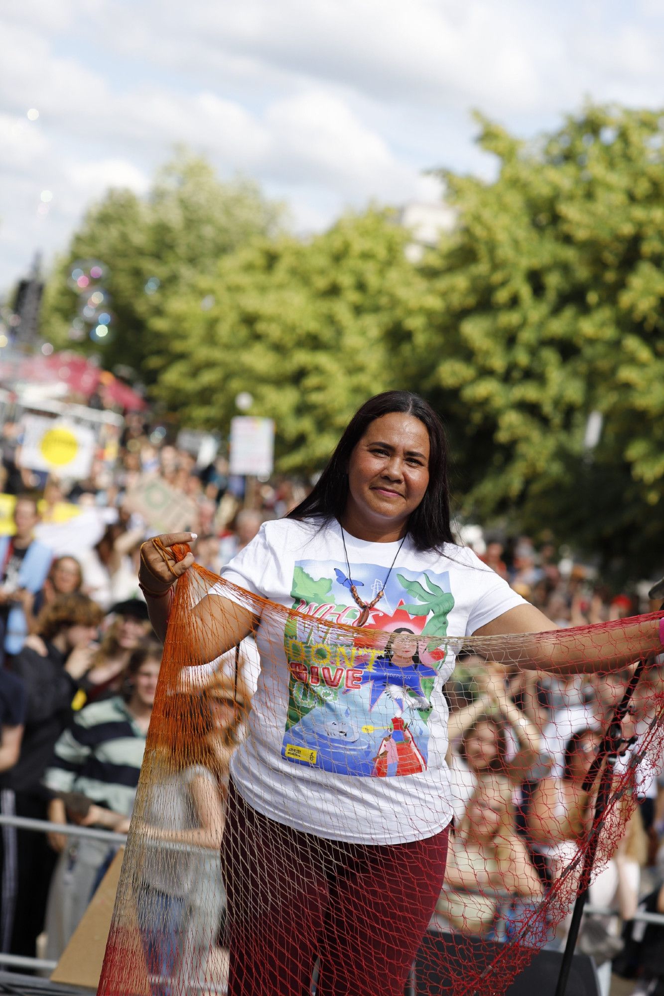 Yuly Velázques hält ein Fischernetz auf der Bühne des Klimastreik in Berlin in die Höhe.