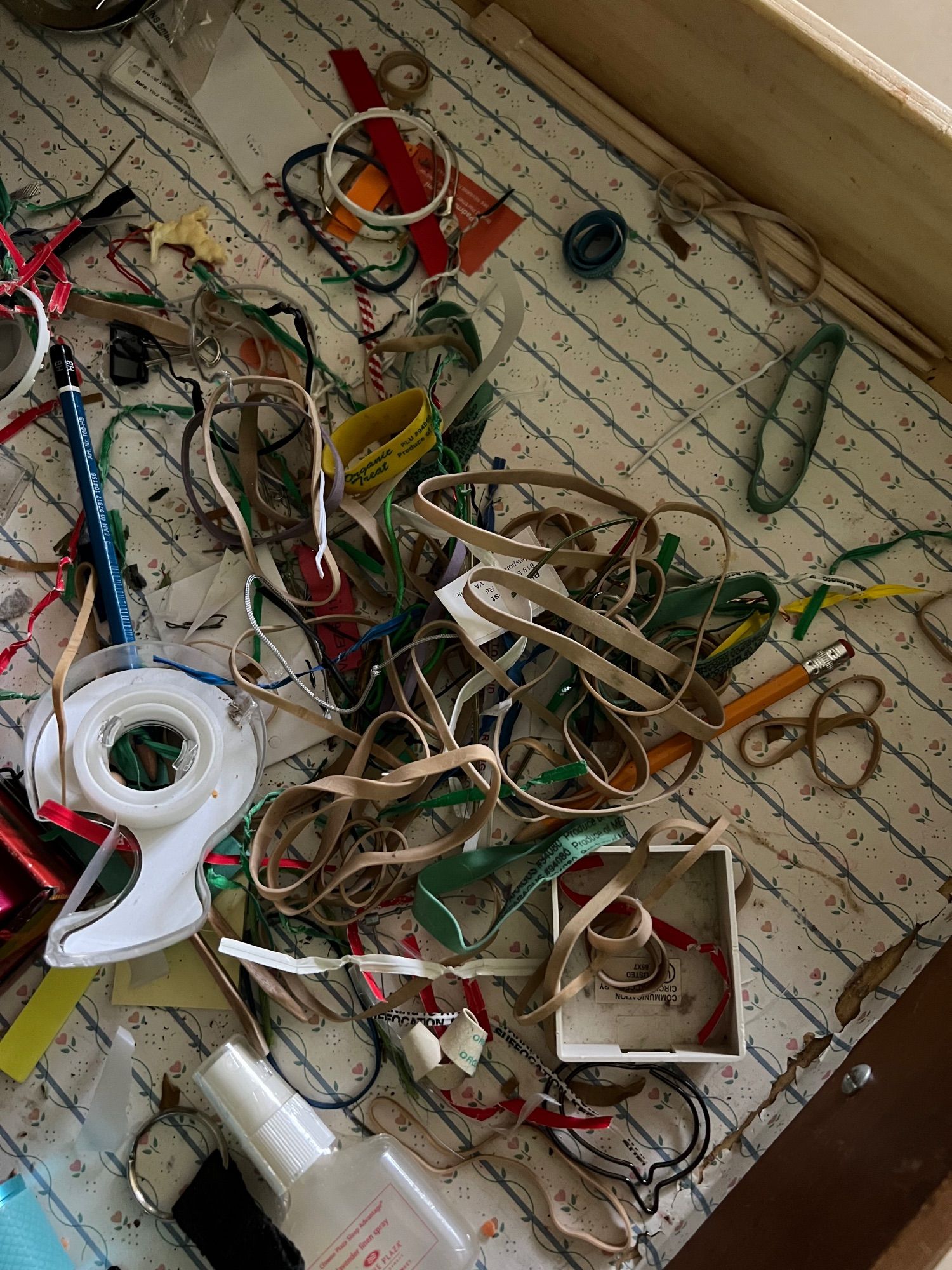 The random detritus at the bottom of a kitchen drawer: rubber bands, tape, paper clips, binder clips, part of an old telephone jack…