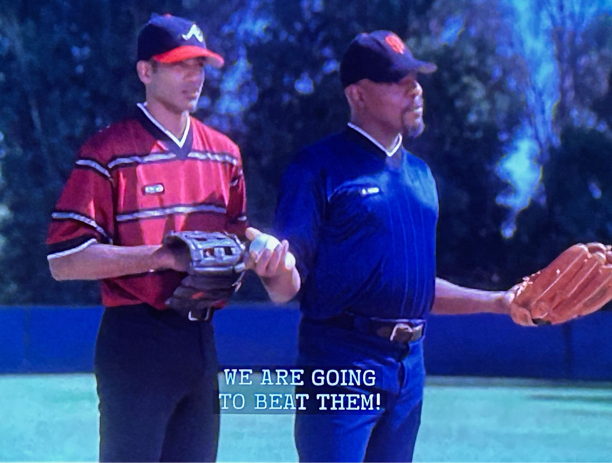 Screenshot of Star Trek ds9: both Sisko and bashir are in baseball uniforms in what appears to be a stadium field: Sisko is giving a rousing pep talk to the team: we are going to beat them! He shouts