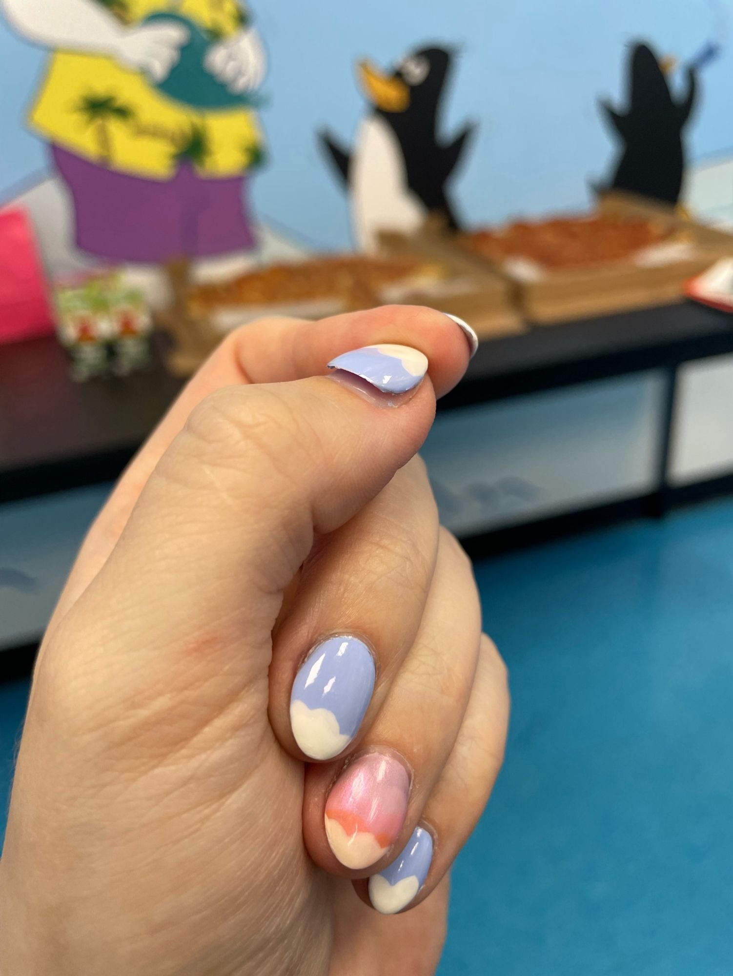 My left hand, 4 nails unscathed (painted periwinkle with white cloud tips, and a sunset-coloured accent nail), but the acrylic dip overlay on my thumb nail is lifting off.