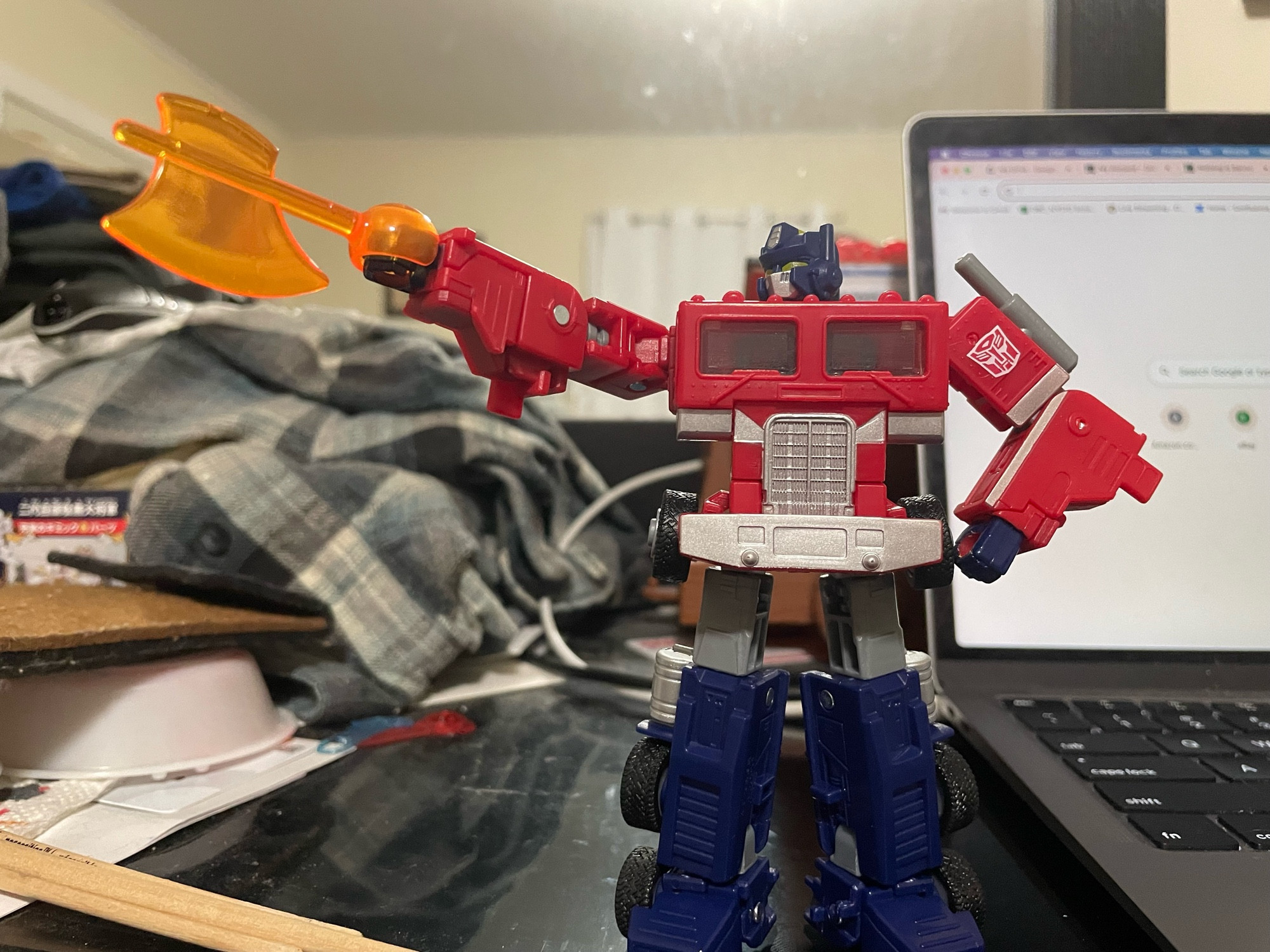 Optimus making a tally-ho gesture with his Energon axe-equipped right hand, and his left arm still akimbo. My flannel sits in a big lump behind him