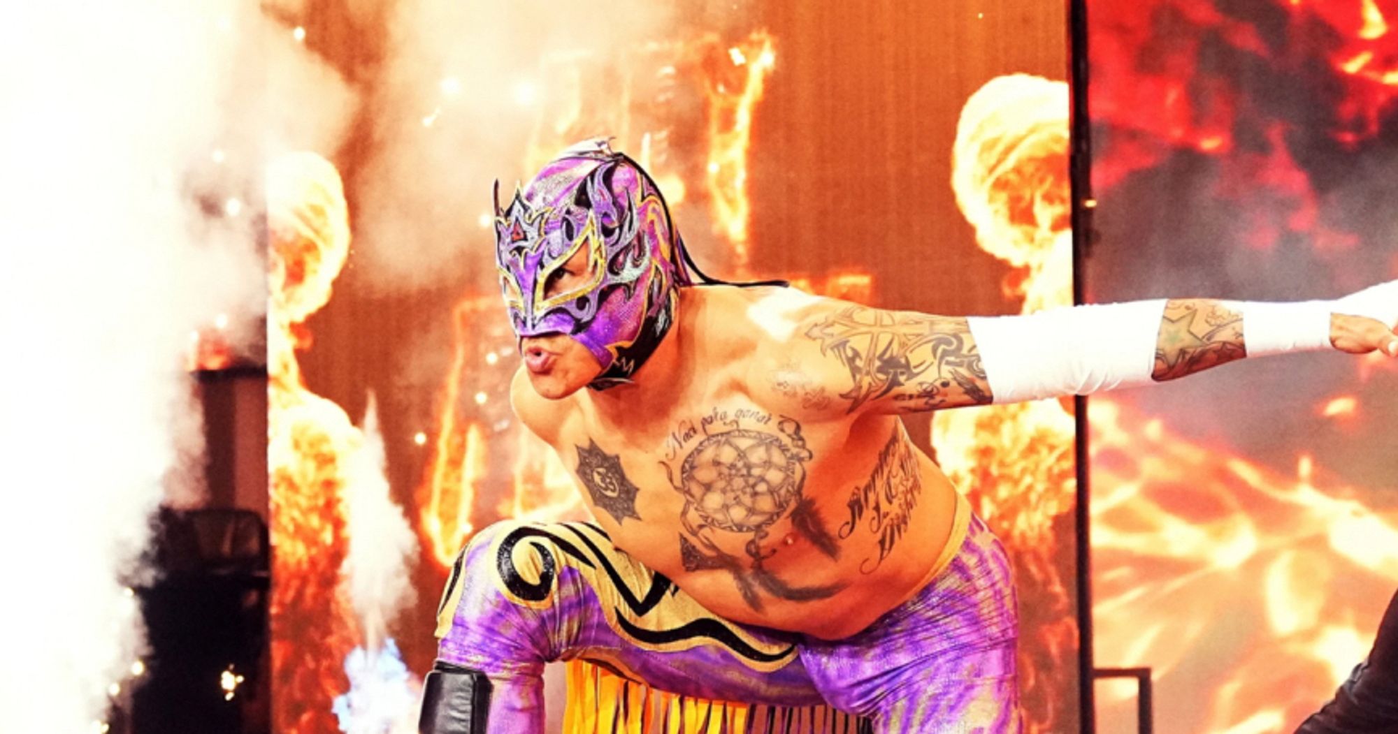 Rey Fenix in the royal purple tights and mask with gold and black trim, including gold tassels on the right leg