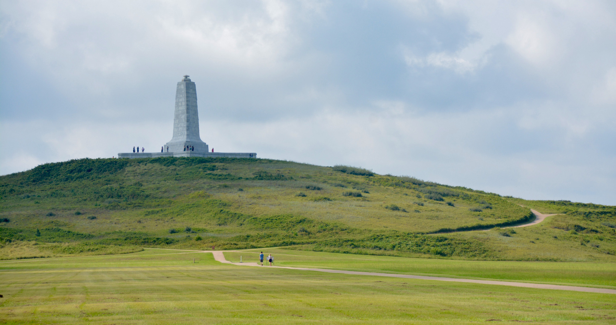 The Wright Brothers National Monument, a stone spire on top of a long green hill in Kill Devil Hills, NC.