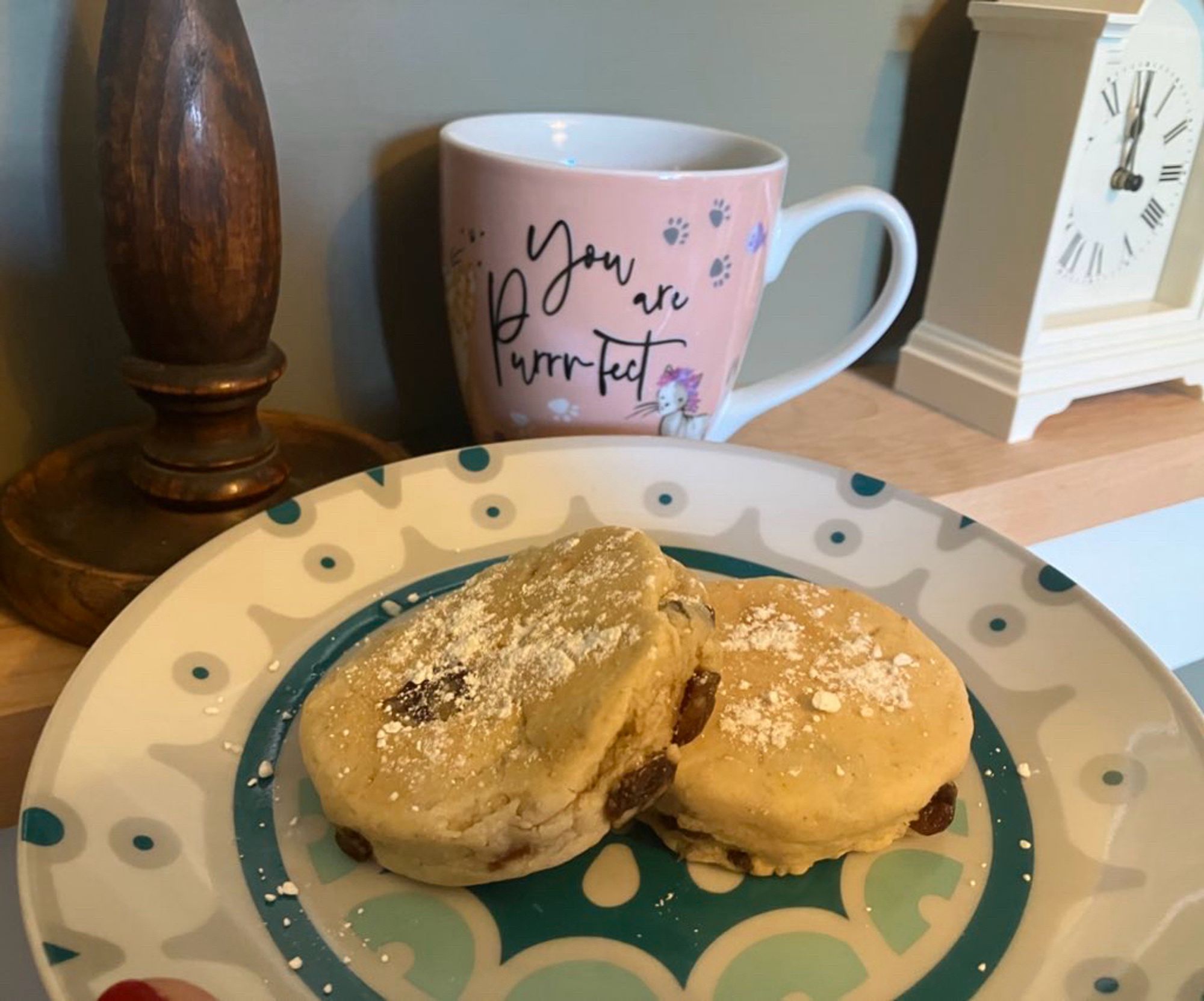 A plate of Welsh cakes in front of a cup of tea.