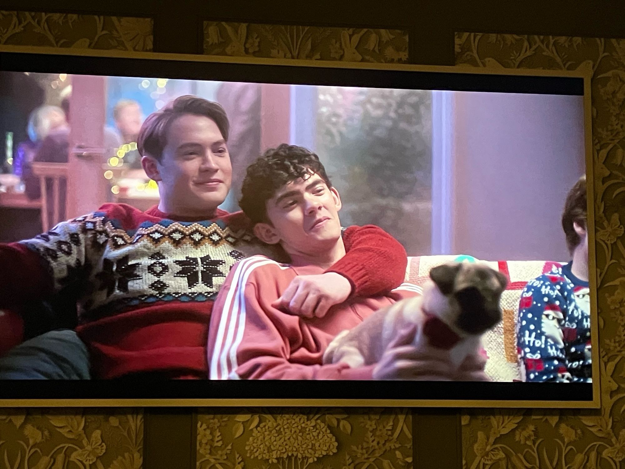 Nick and Charlie from Heart Stopper on the sofa in Christmas jumpers