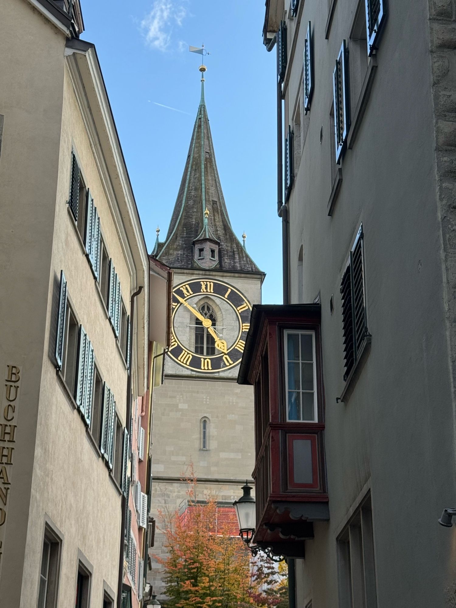 Sicht auf Kirchturm der St. Peter Kirche zwischen Häusern hindurch