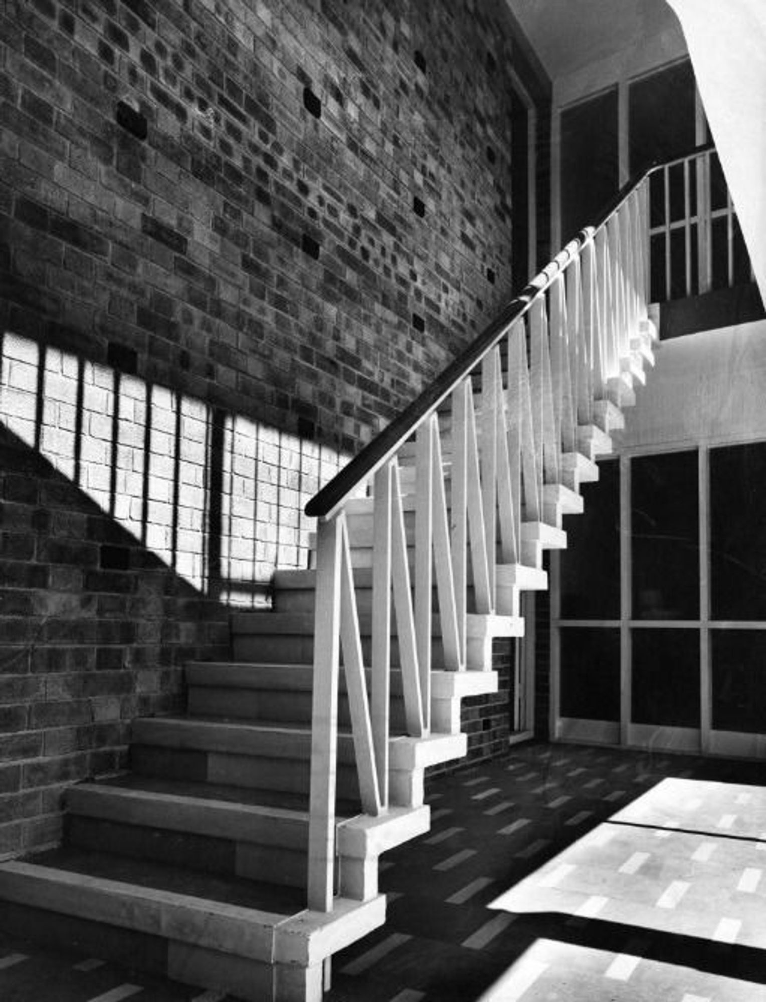 A black and white photograph of the ironwork staircse inside the entrace of flats on Hampton Road