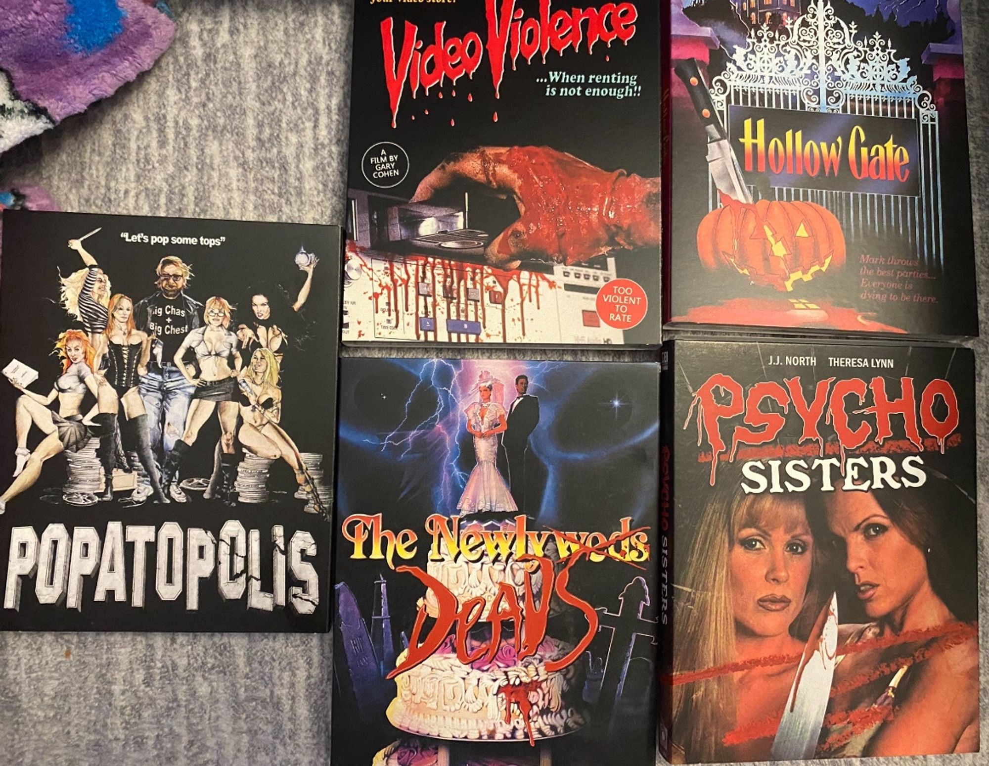 Blu ray discs of The Newlydeads, Psycho Sisters, Hollow Gate, Video Violence 1 & 2, and Popatopolis