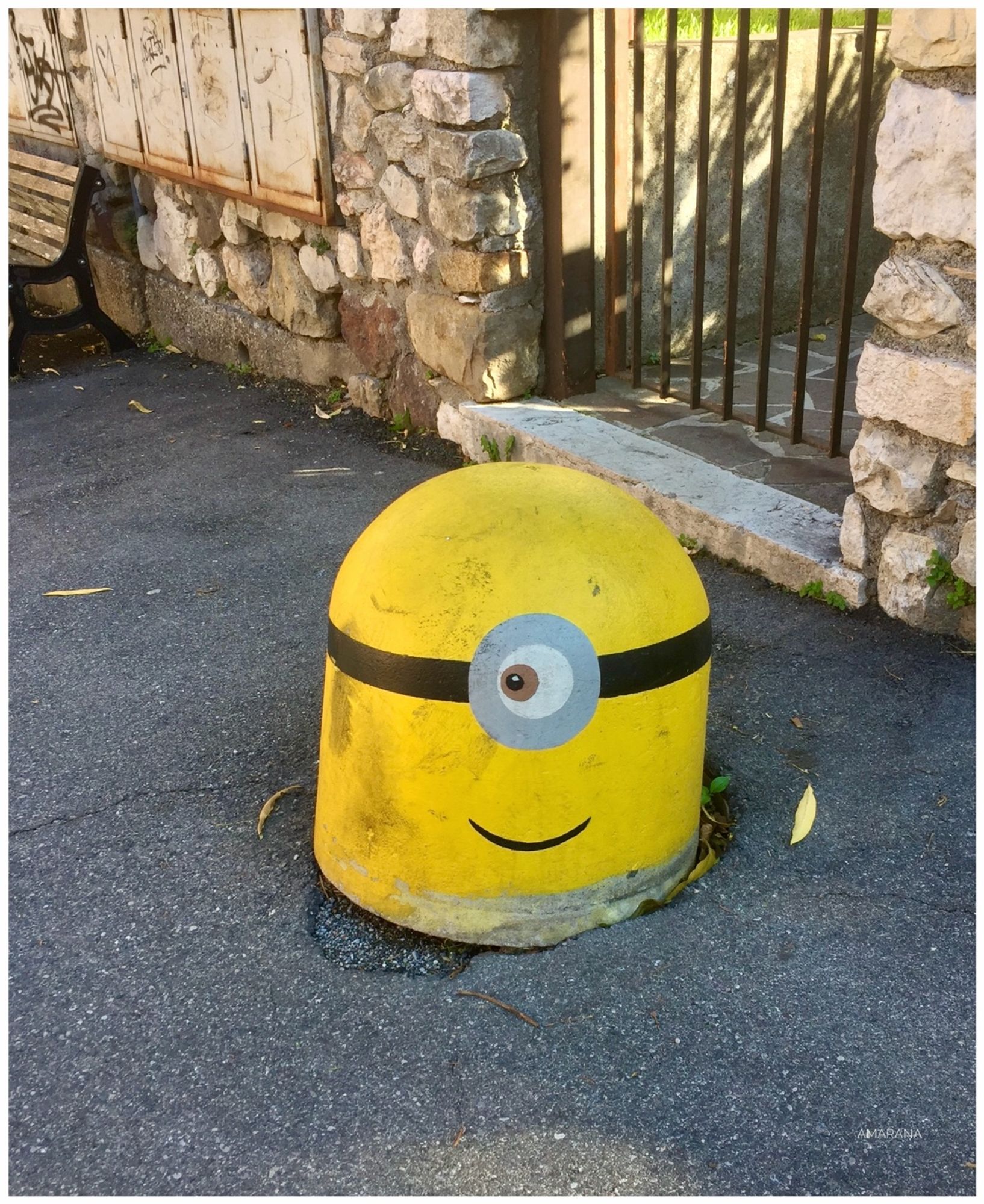 Ein gelber Poller, dem ein Auge aufgemalt wurde und der jetzt aussieht wie ein Minion