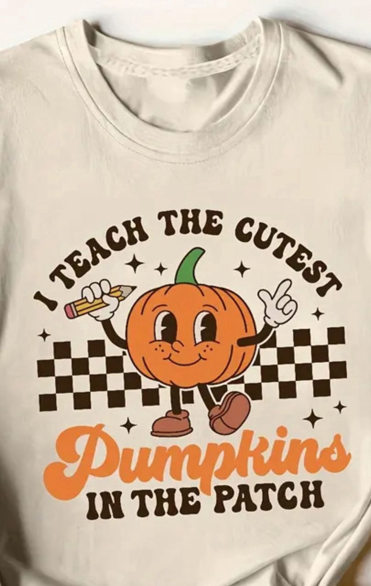 A T-Shirt featuring a cute sentient pumpkin that says “I teach the cutest pumpkins in the patch”