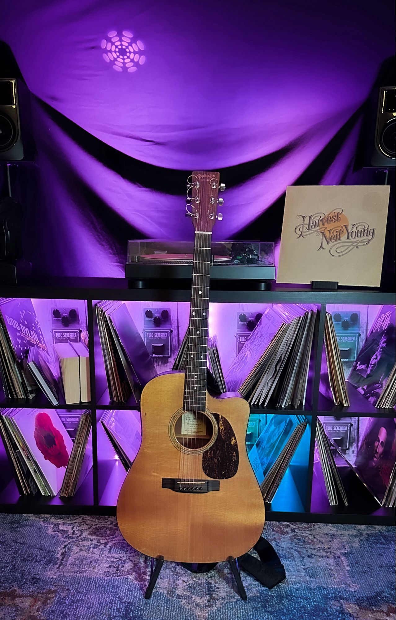 A Martin Acoustic Guitar with Neil Youngs record Harvest in the background.