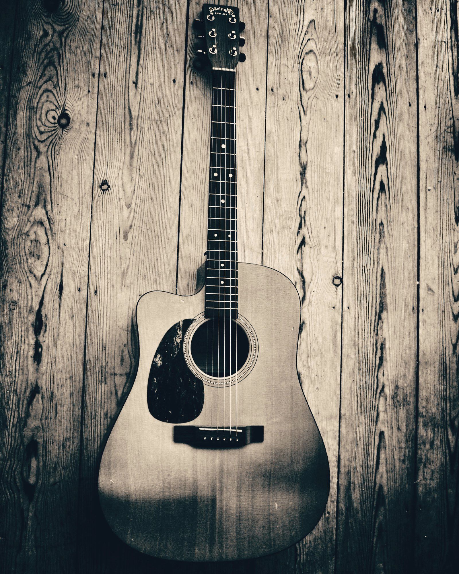 A Martin Acoustic Guitar on a wooden floor.