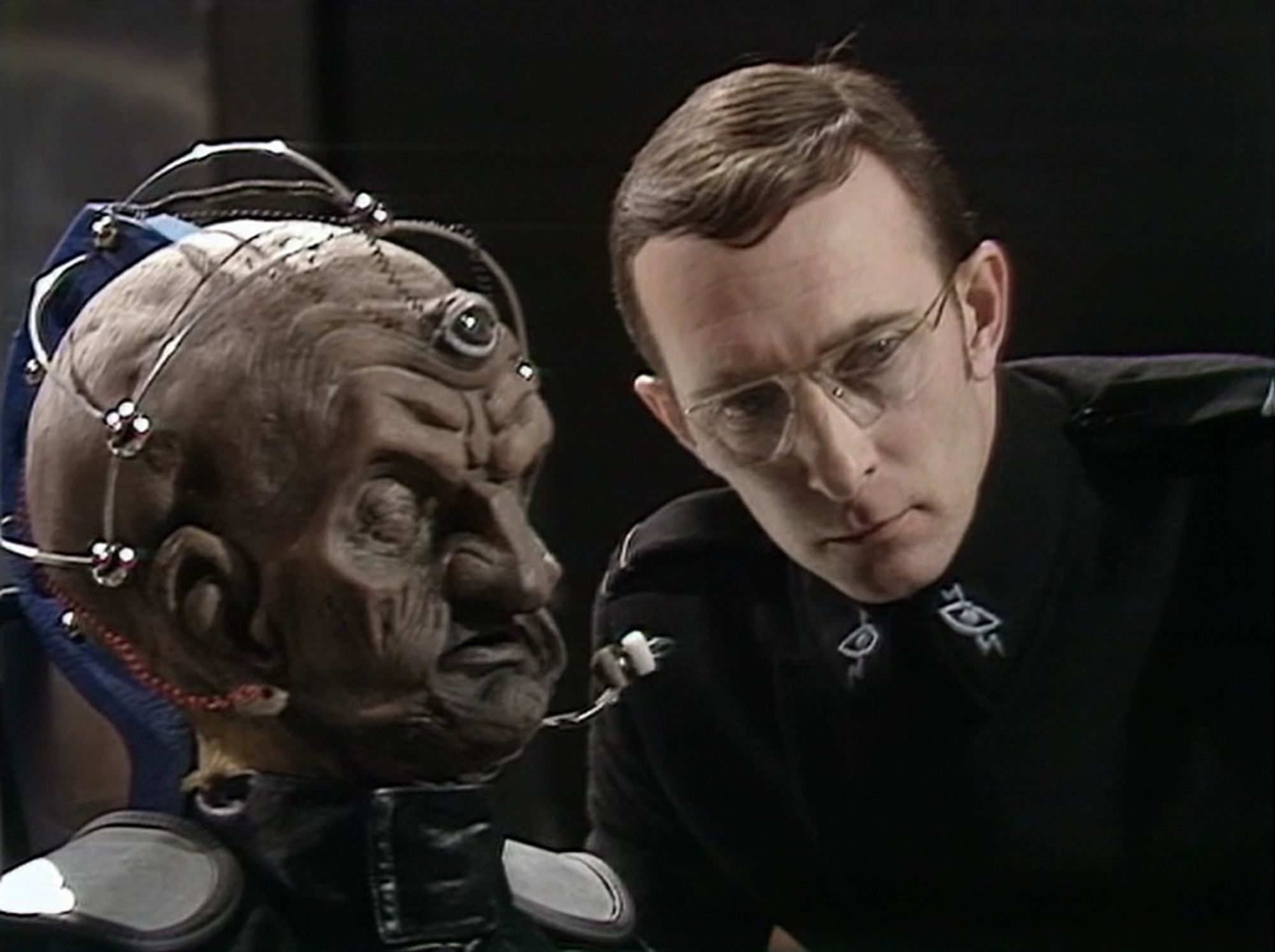 Nyder, leaning close to Davros.