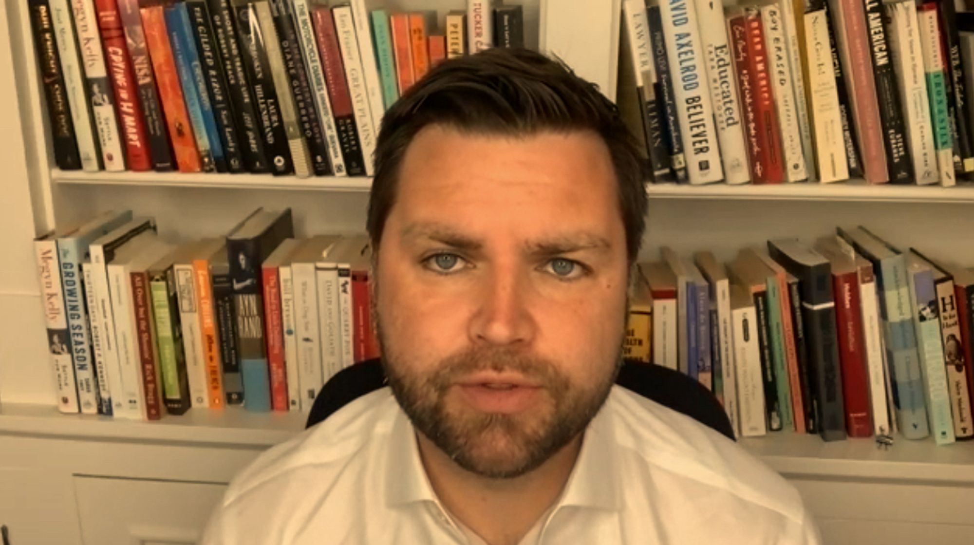 JD Vance sits before a bookshelf for a video interview